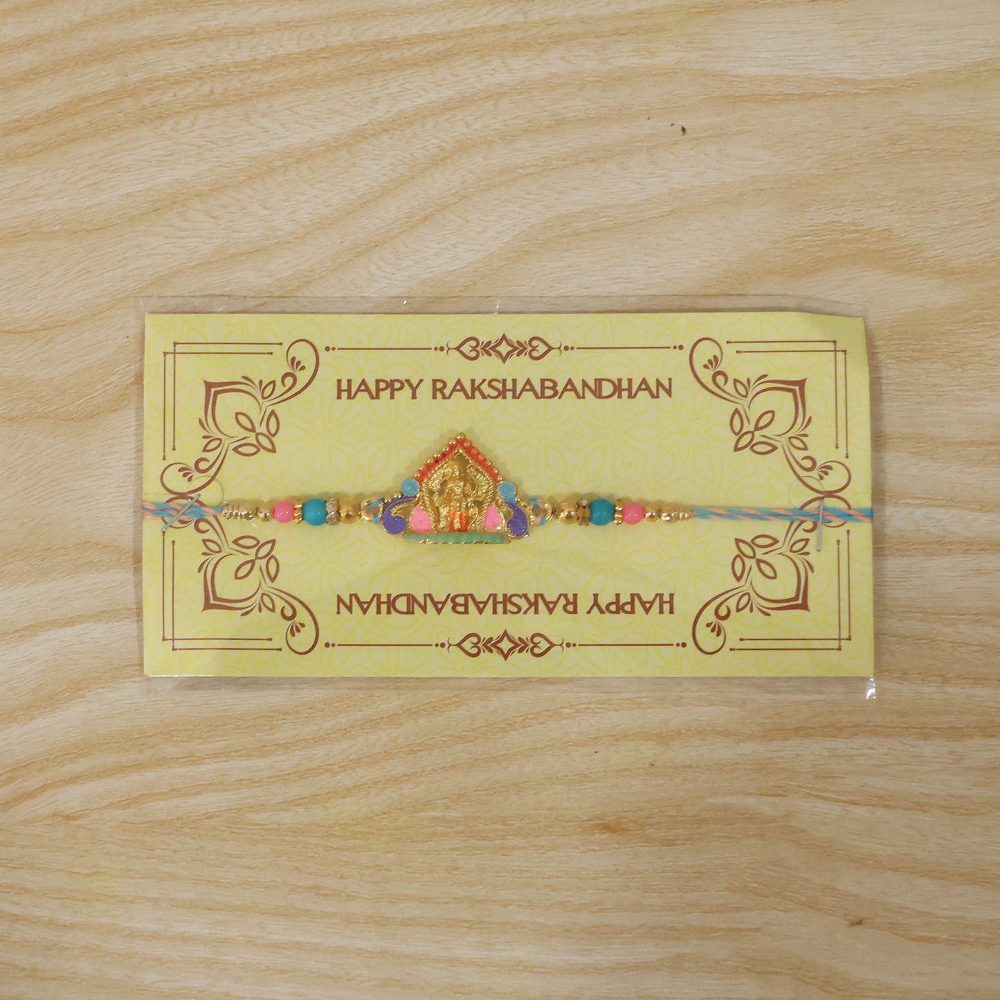 Vibrant designer Rakhi with idol charm