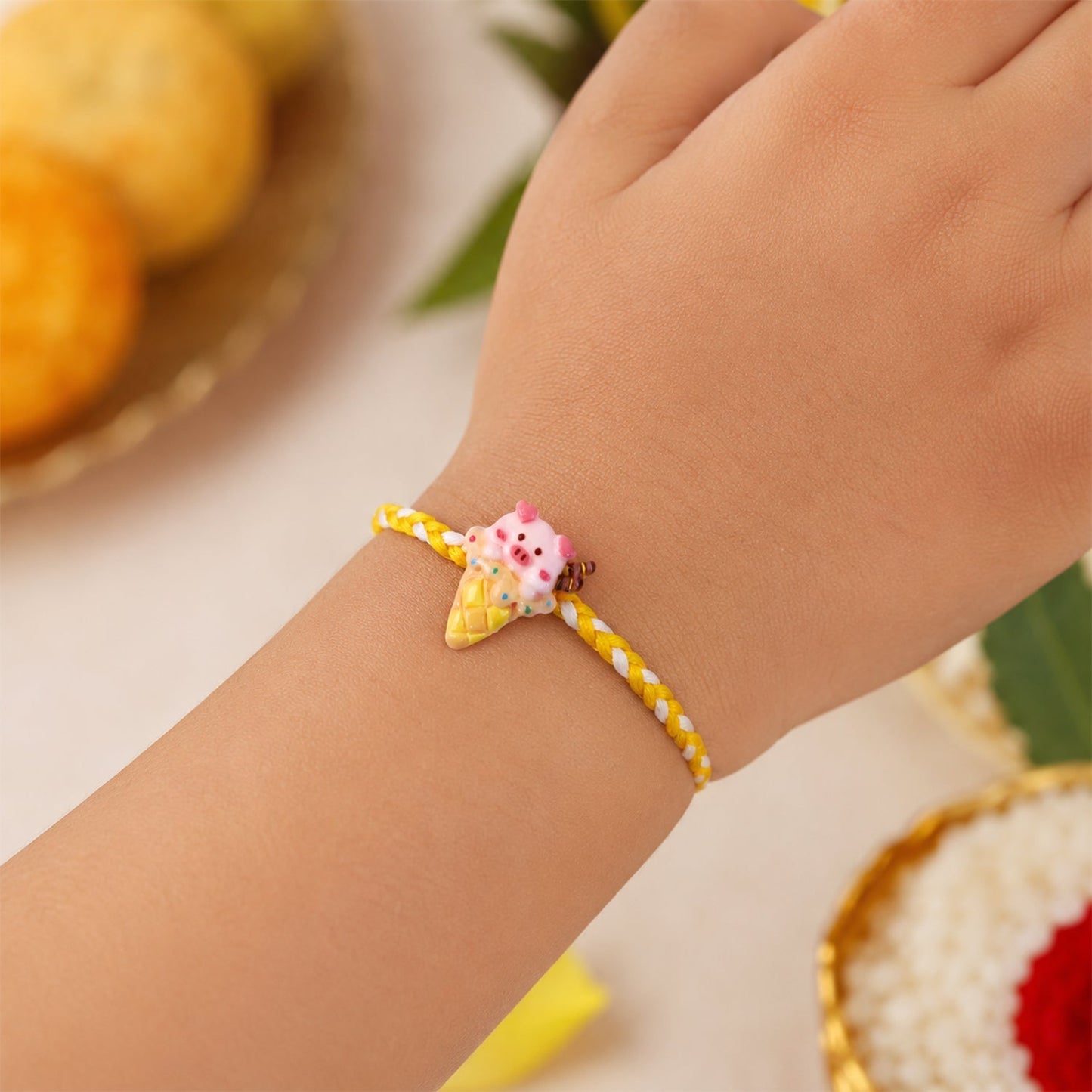 Side profile of the fancy dori Cute Pig Rakhi highlighting its intricate threadwork.
