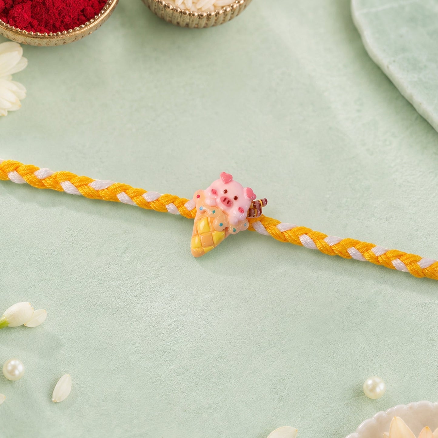 Overhead shot of Cute Pig Rakhi with playful design.
