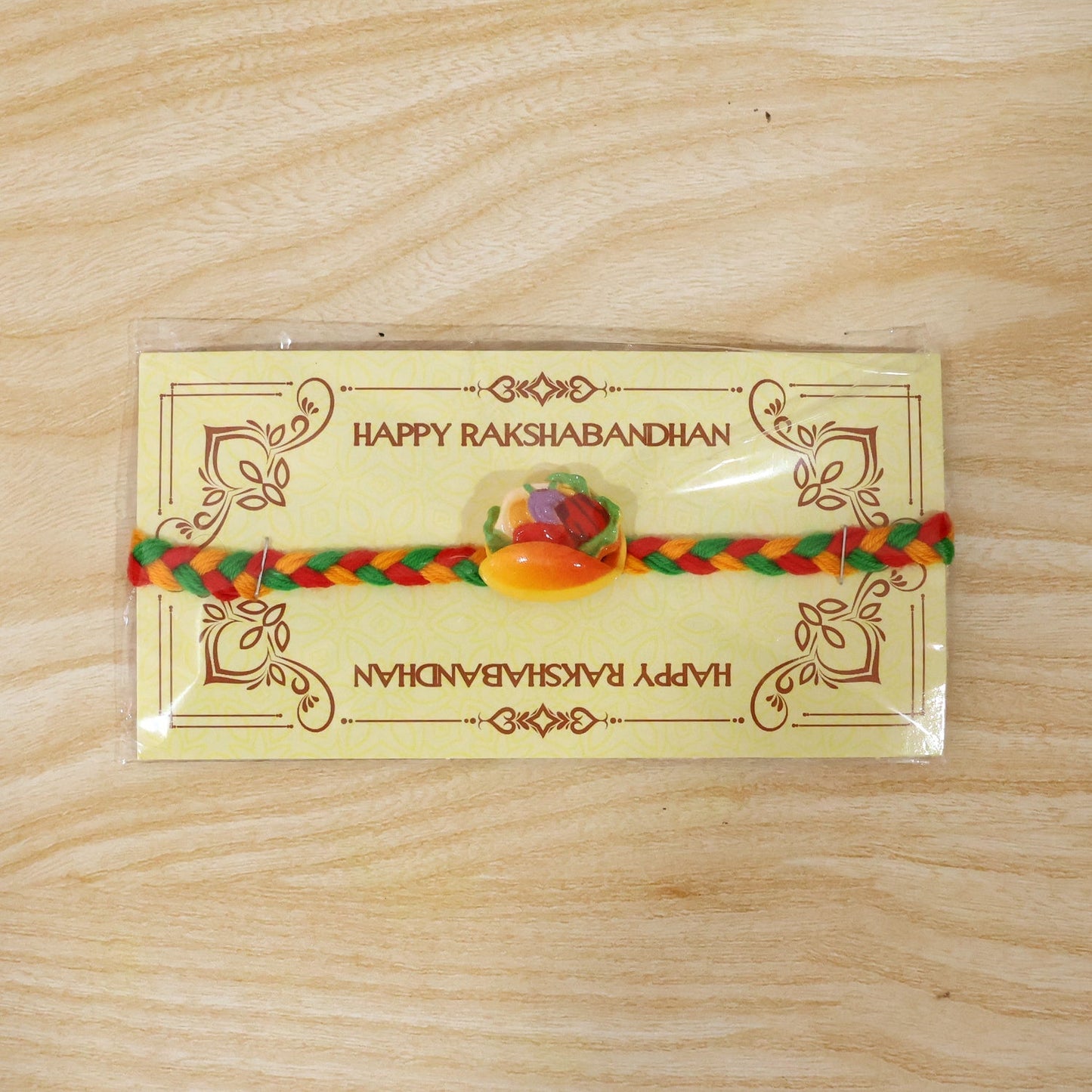 Dori Rakhi with colourful fruit design, ready to be tied on a brother's wrist.