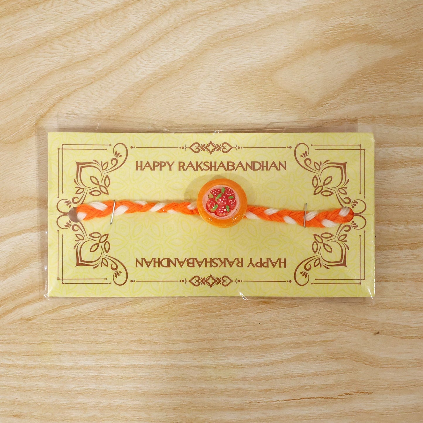 Decorative elements of strawberry themed brother rakhi