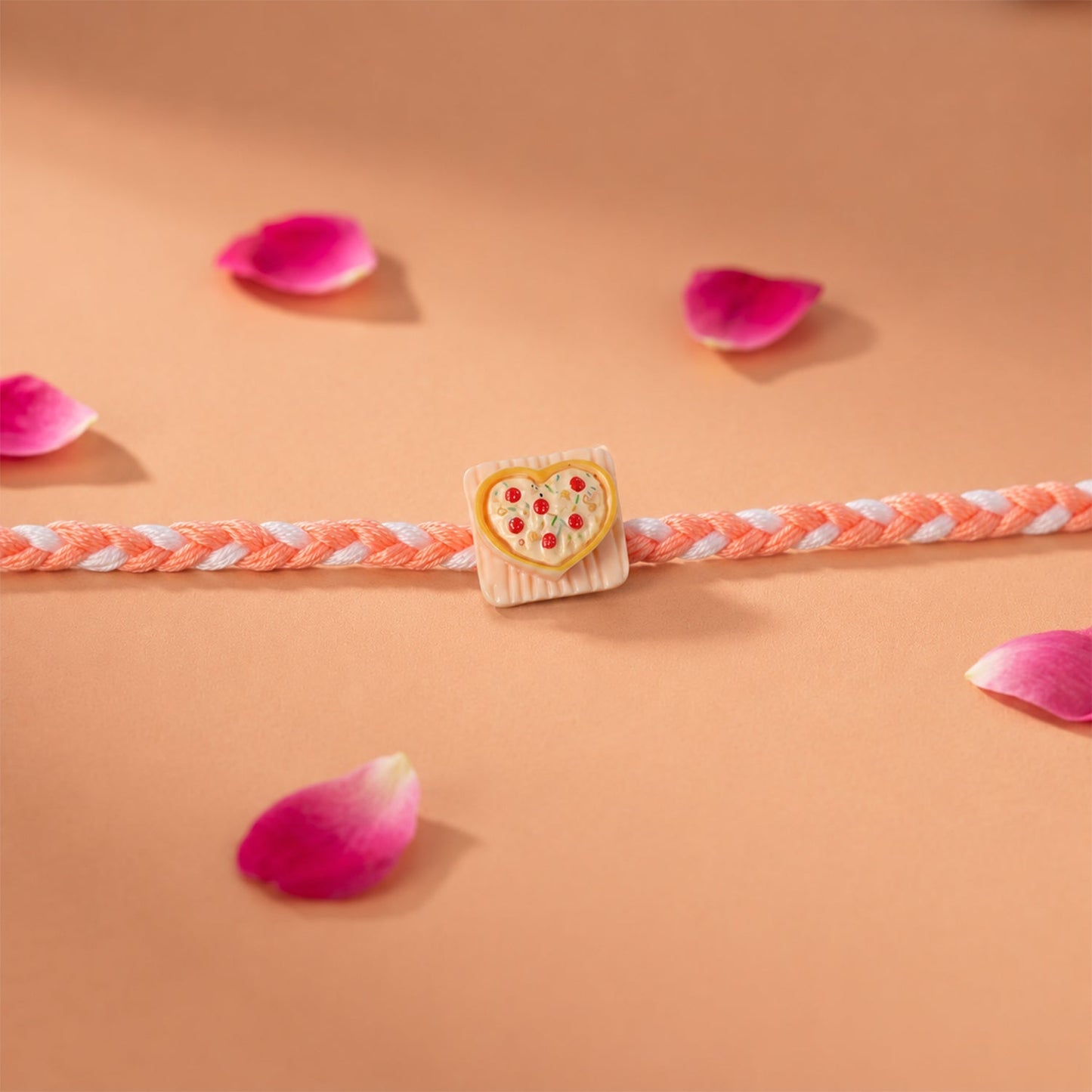 Side view of the Rakhi showcasing the elegant dori and charm