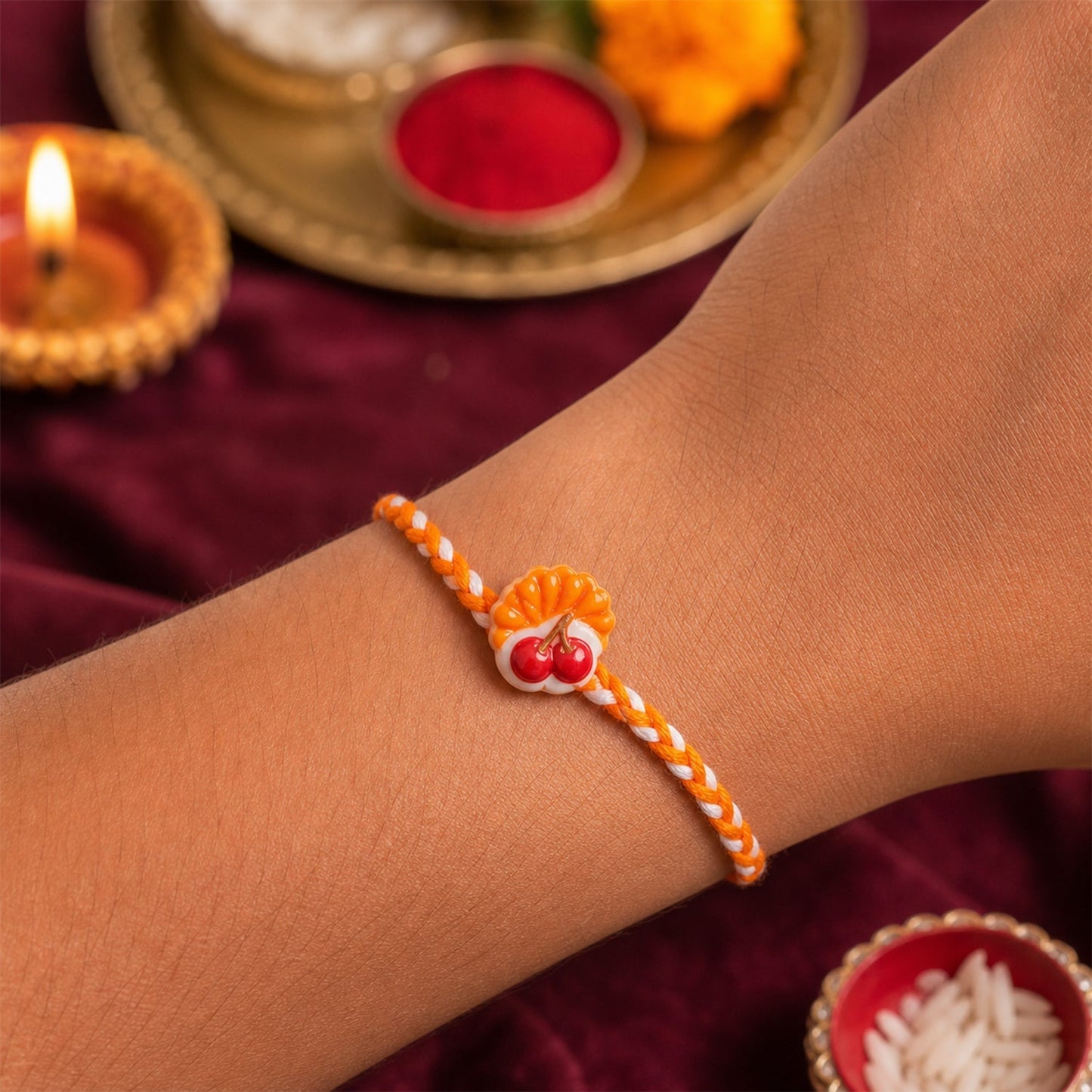 Detailed close-up of the Cherry Pastry Charm Dori Rakhi, highlighting its intricate design.