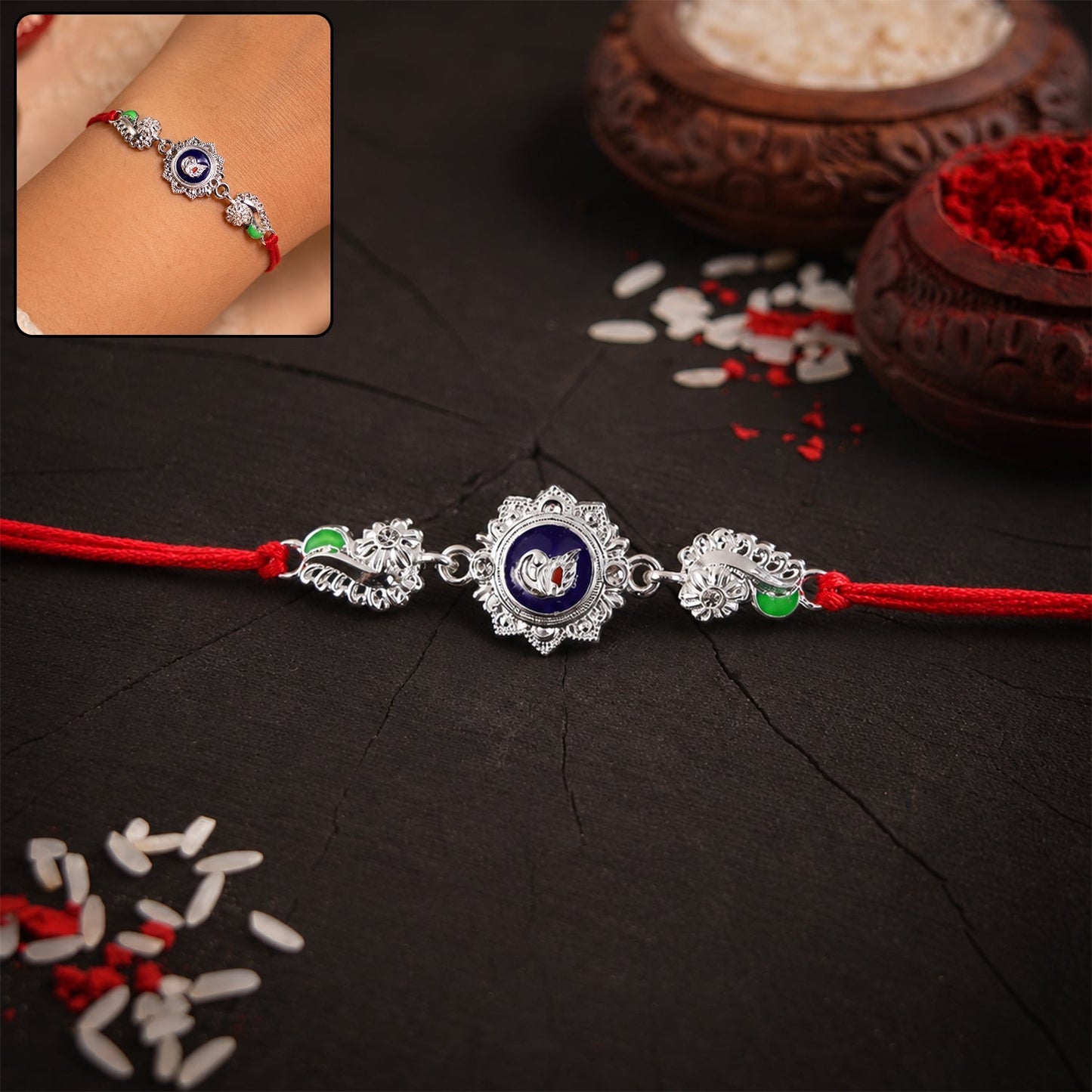 Silver round charm rakhi with red thread on white background