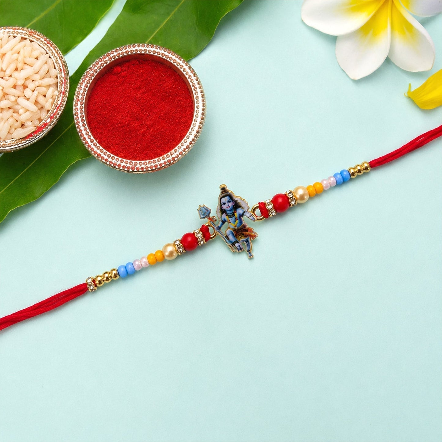 Close-up of designer rakhi with Mahadev idol and vibrant beads