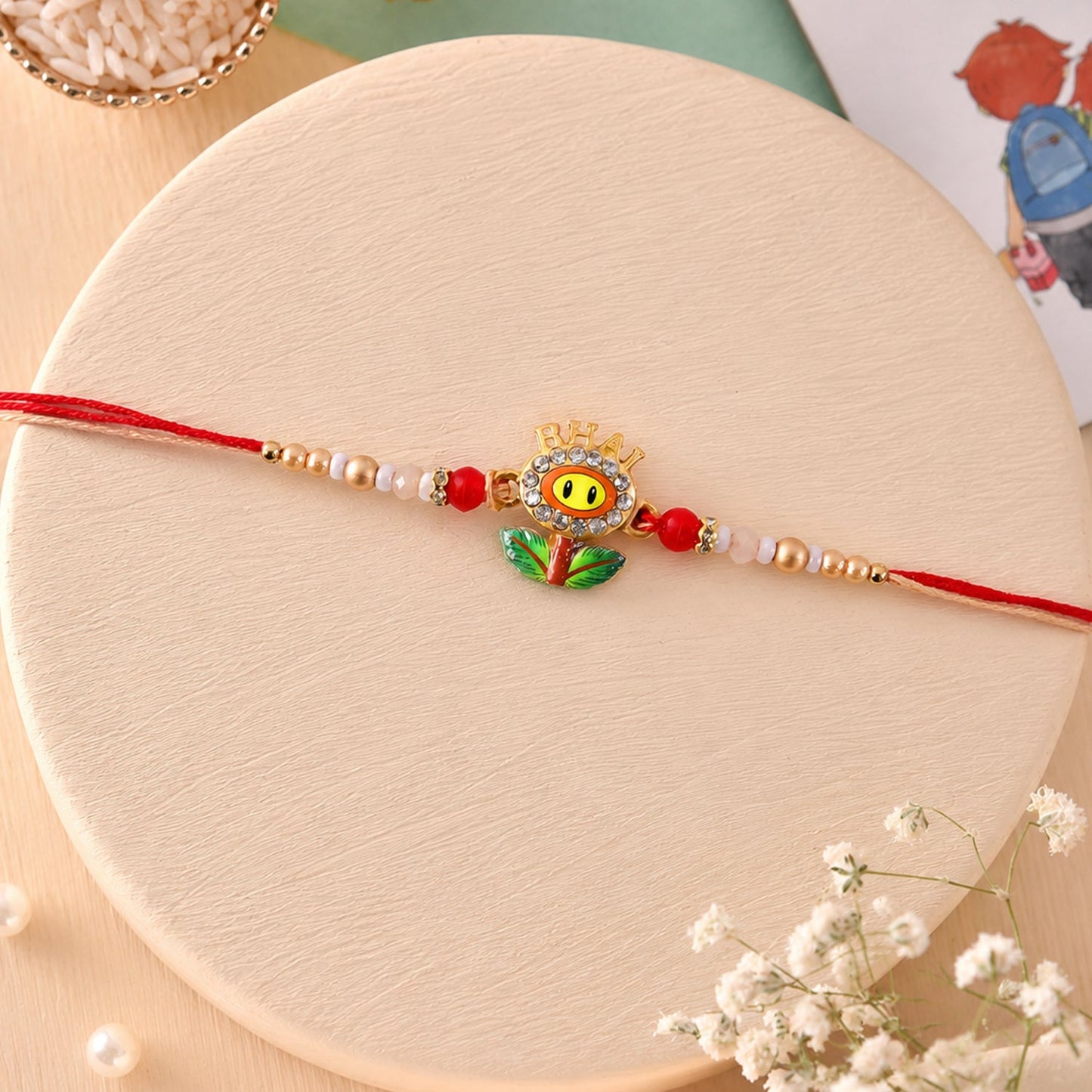 Top view of Smiley Flower Charm Rakhi highlighting its attractive design