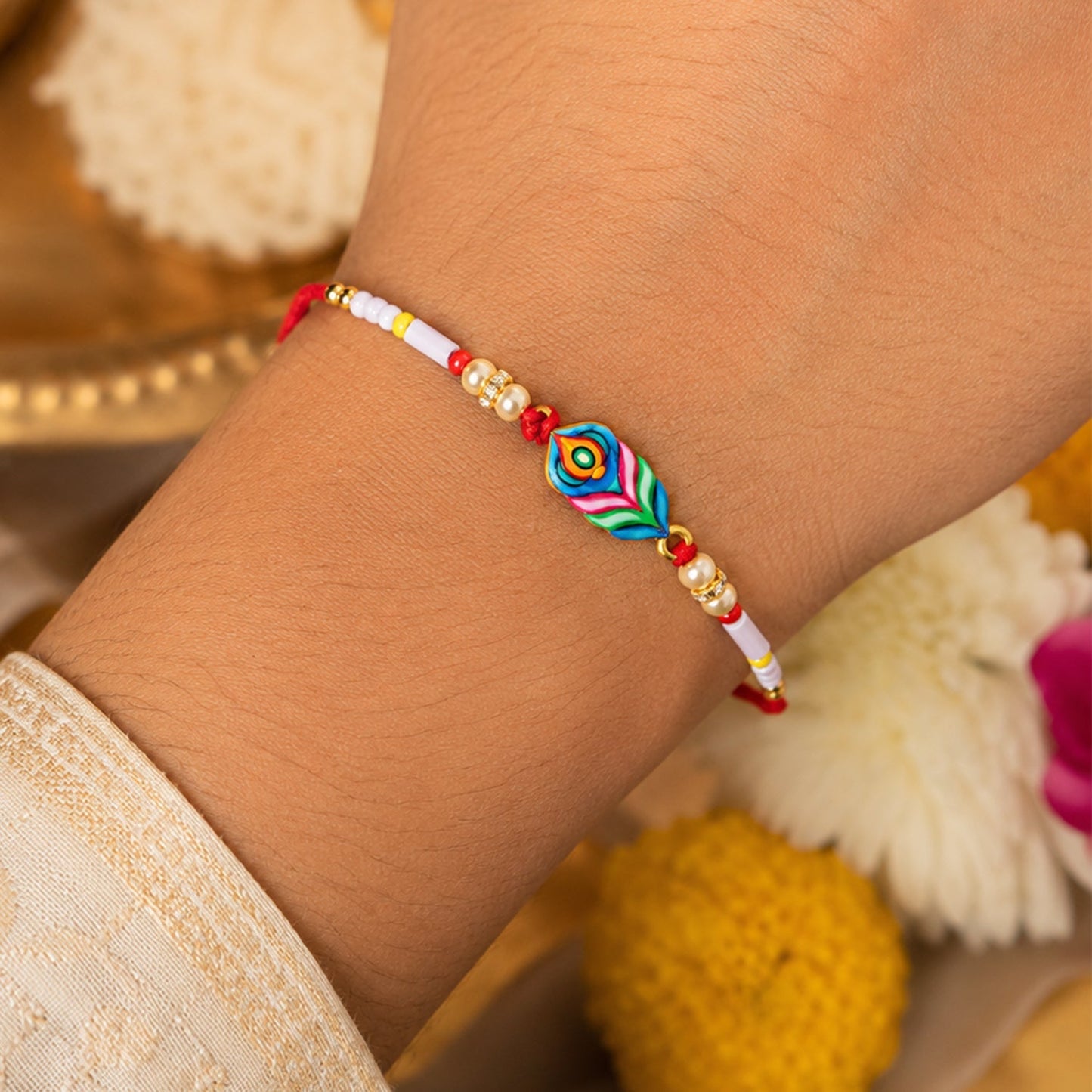 Designer rakhi close-up showcasing vibrant beads and peacock feather detail