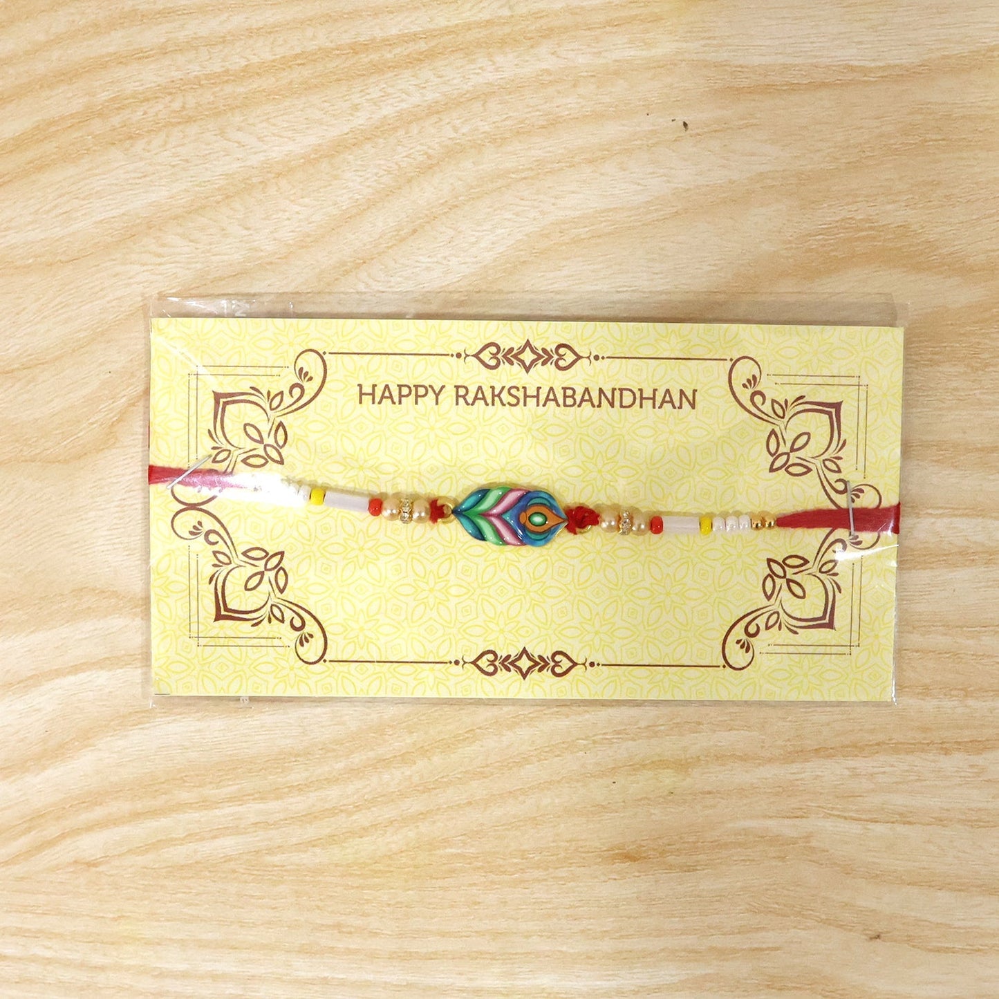 Close-up of handcrafted beaded rakhi featuring Mor Pankh charm and vibrant colours