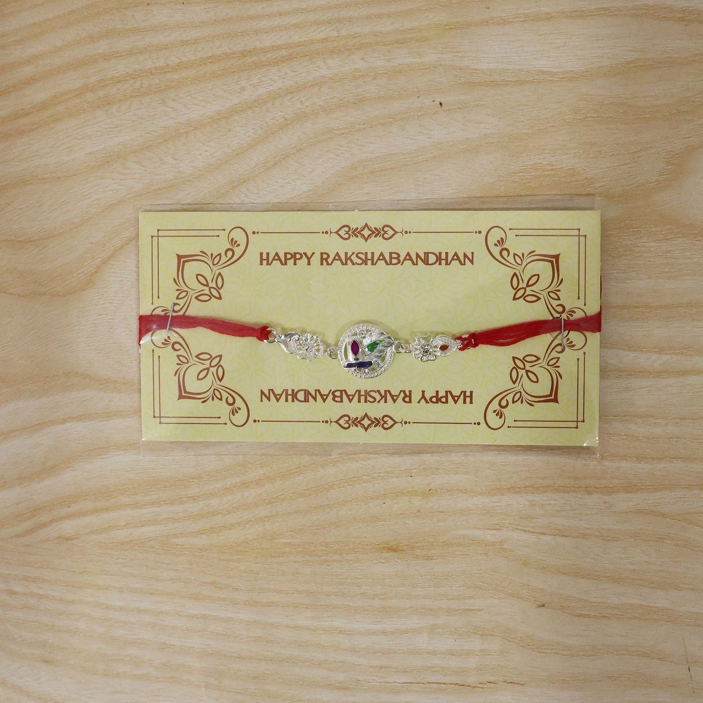 Full-length view of silver rakhi with thread for brothers