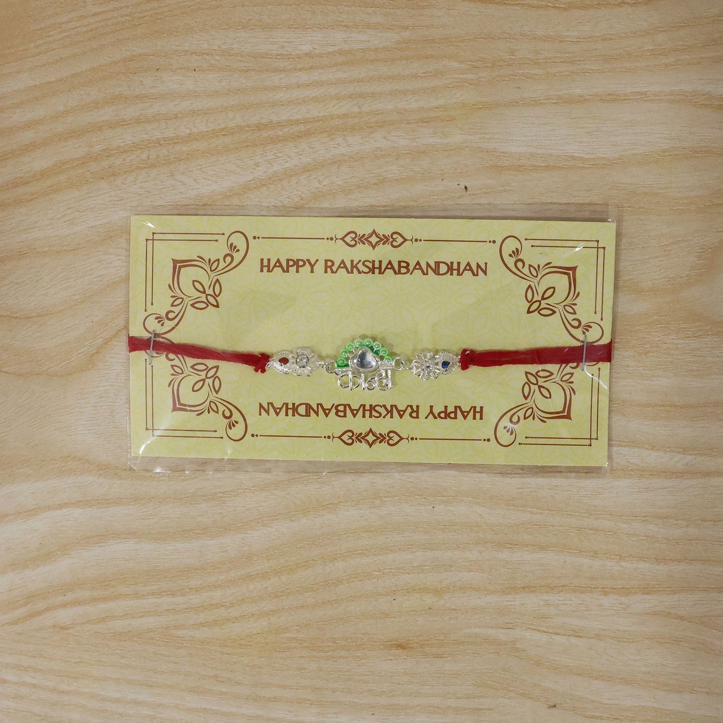 Elegant presentation of Silver Kanha Mor Rakhi in packaging