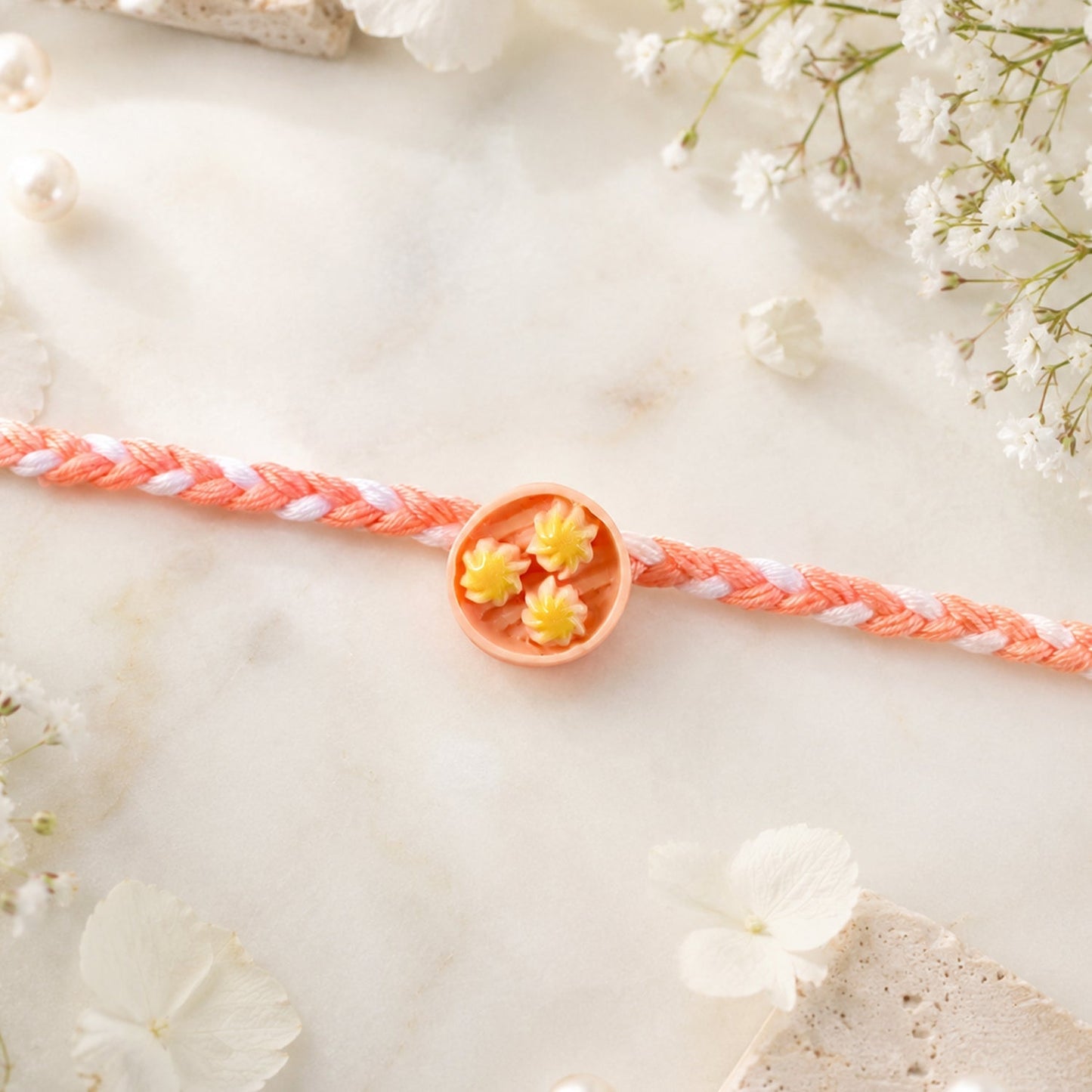 Braided thread Rakhi highlighting intricate charm detail