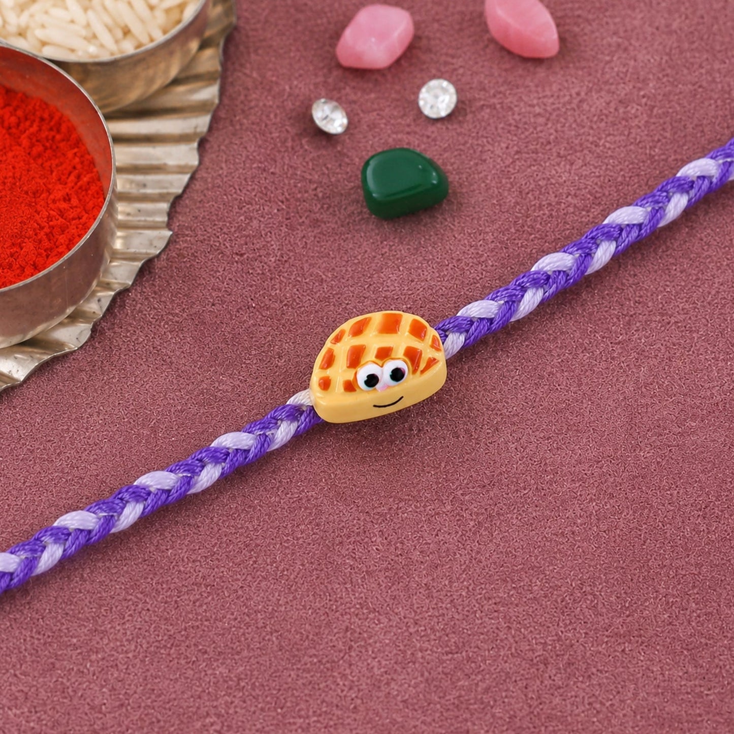 Close-up of Smiley Waffle Charm detail on Rakhi
