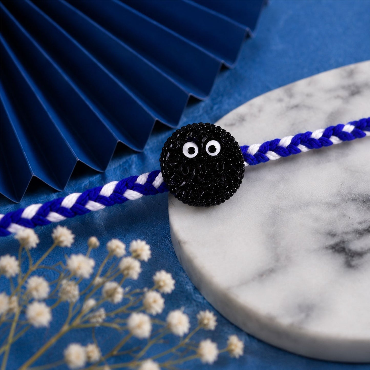 Detail of braided Rakhi thread with decorative cookie eyes charm