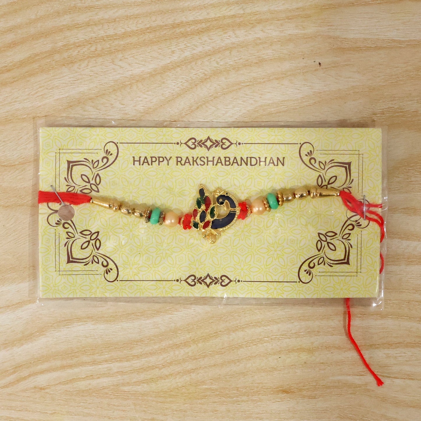 Festive Rakhi with peacock charm and beads for Raksha Bandhan