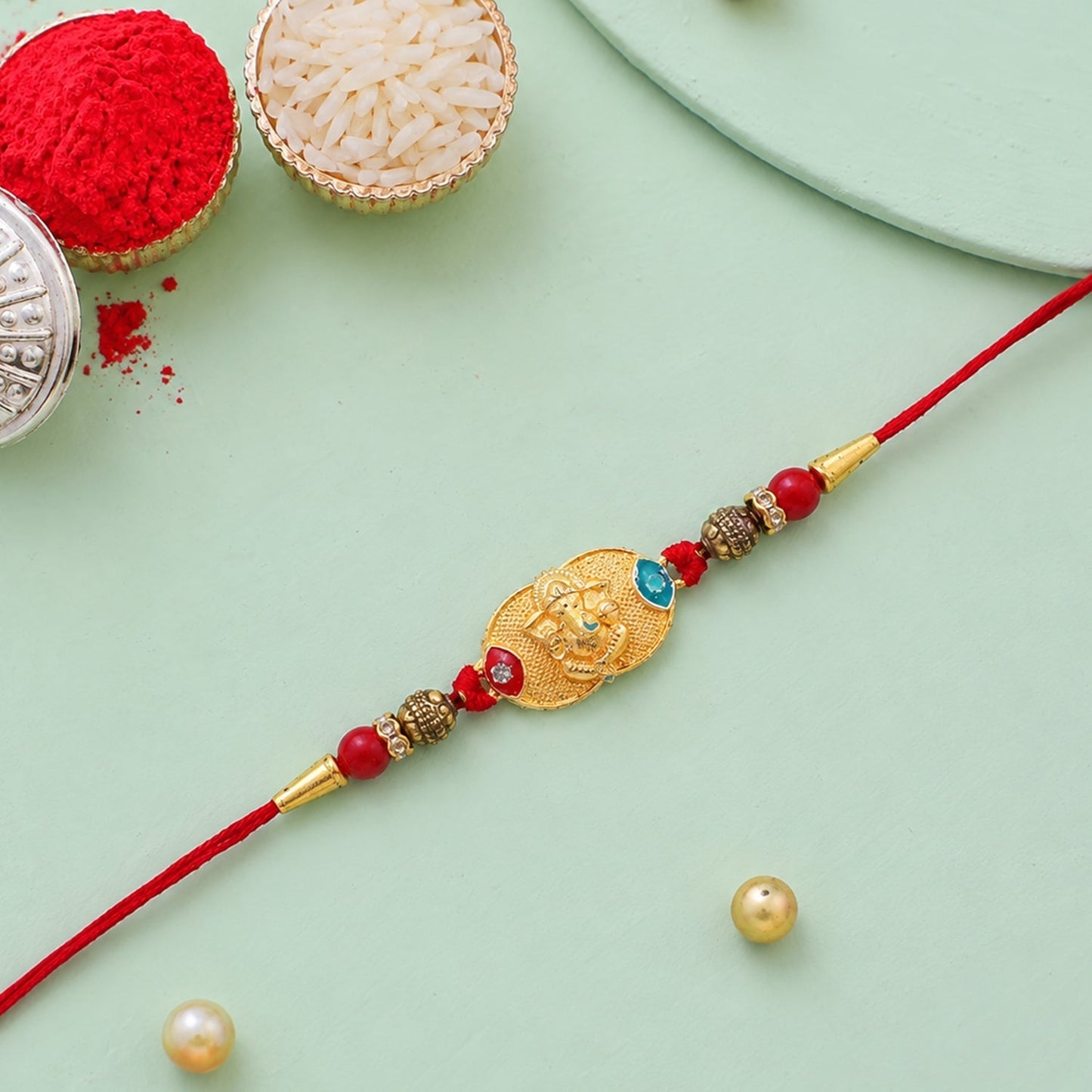 Close-up of Ganesh charm and antique beads on Rakhi