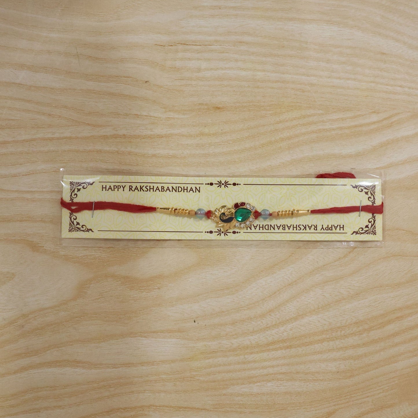 Packaging of Peacock Emerald Stone Rakhi with Pearl Beads for gifting