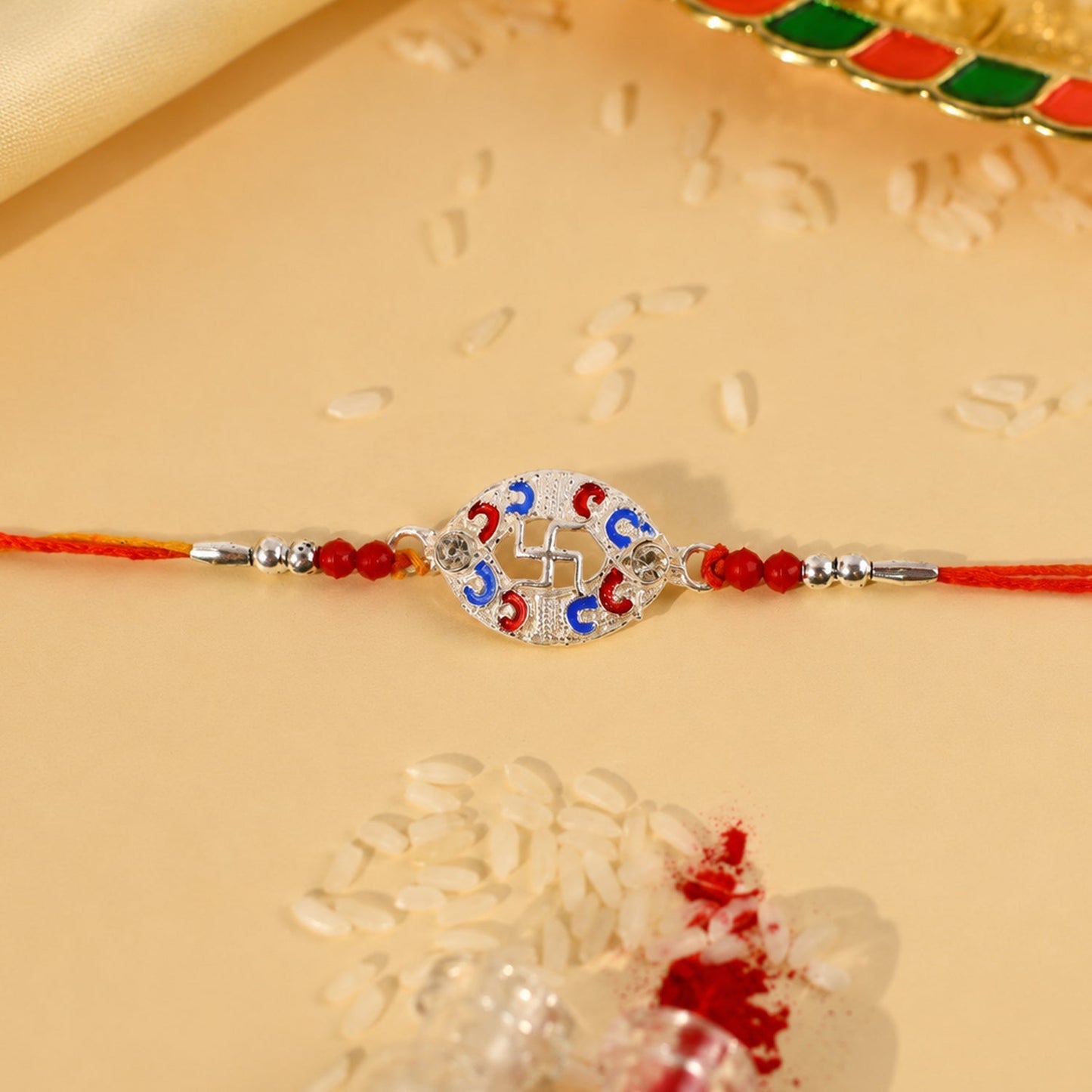 Close-up of Silver Swastik Meena Oval Charm Rakhi beads