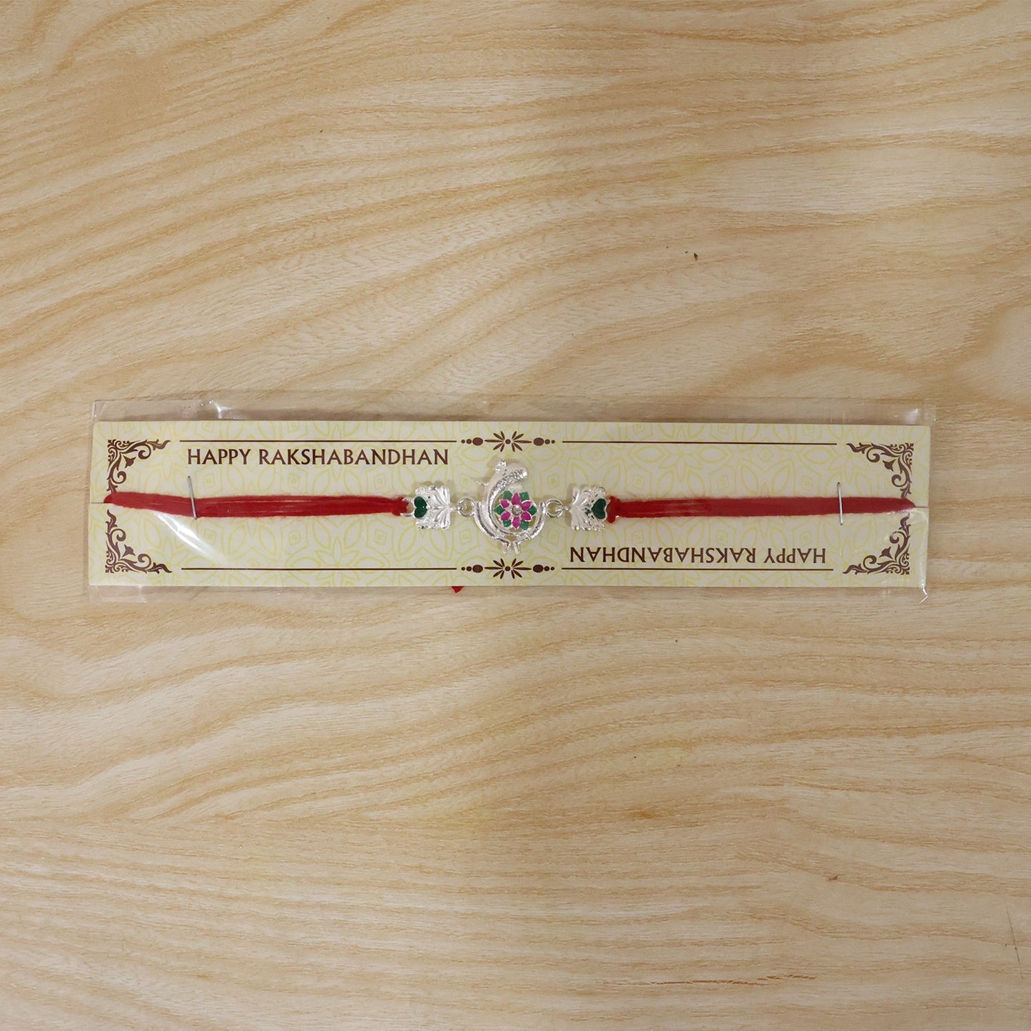 Close-up of flower & heart motifs on Silver Peacock Rakhi