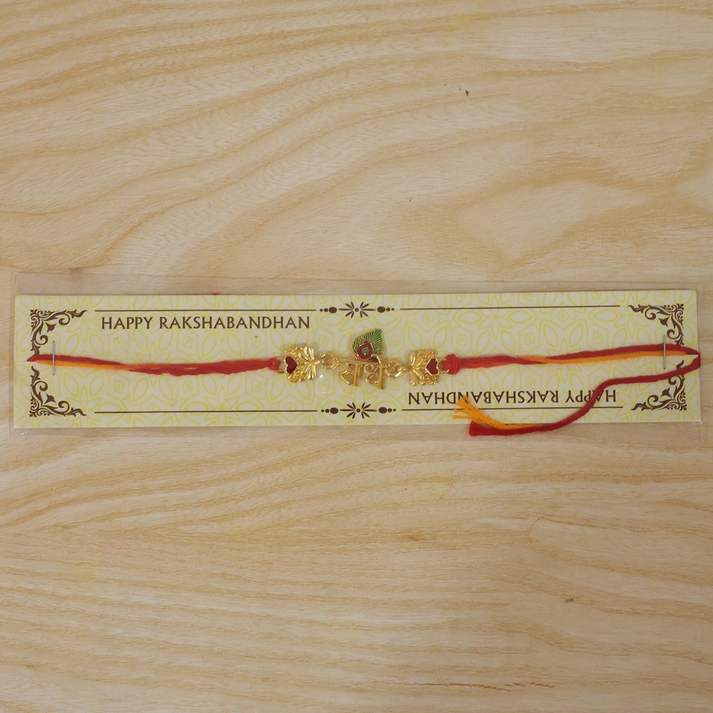 Golden Radhe Peacock Feather Rakhi with festive decorative elements