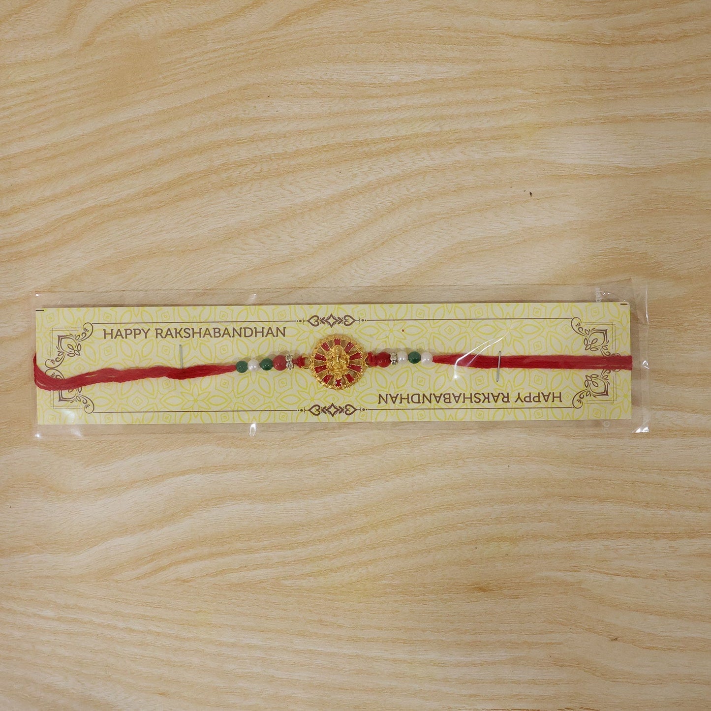 Festive Golden Ganesha wheel Rakhi with attractive centerpiece and beads