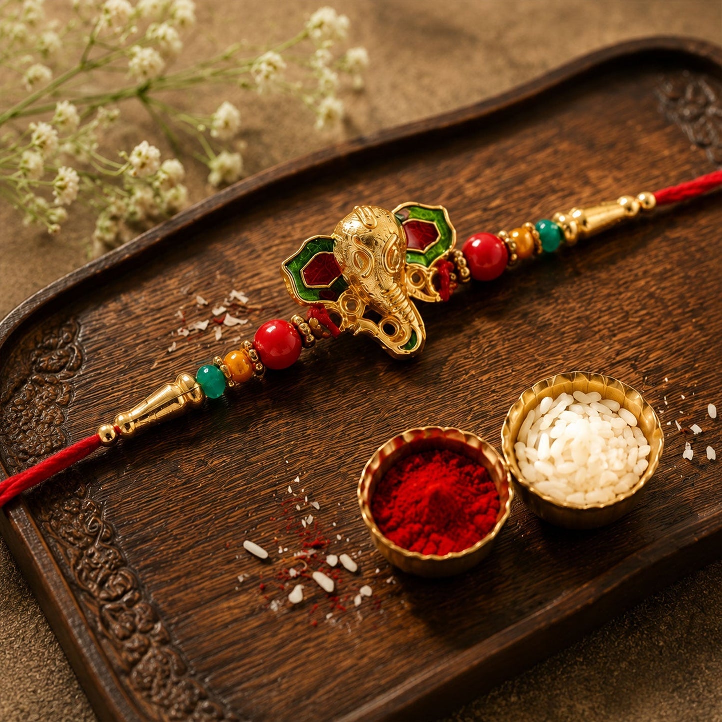 Detailed close-up of Ganesha Rakhi with meenakari work and beads