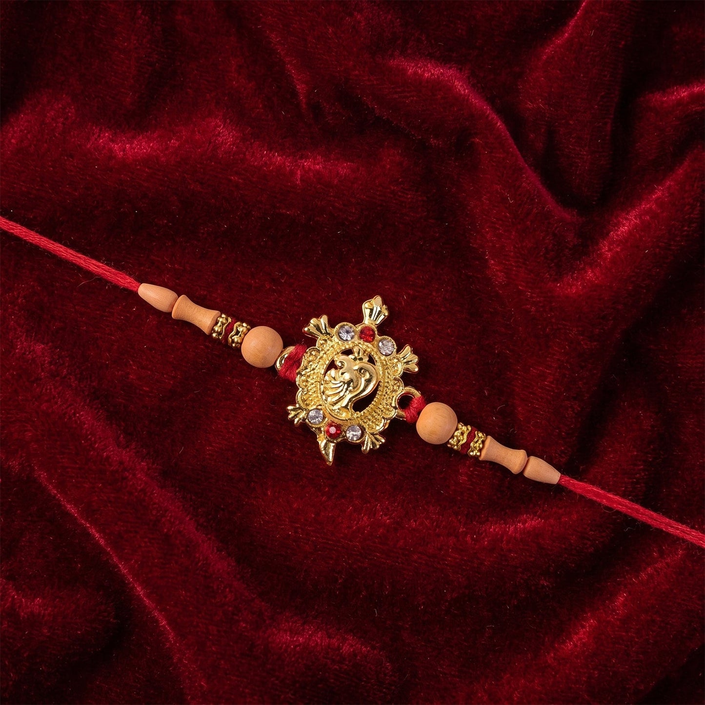 Premium Golden Om Rakhi with beads, perfect for Raksha Bandhan.