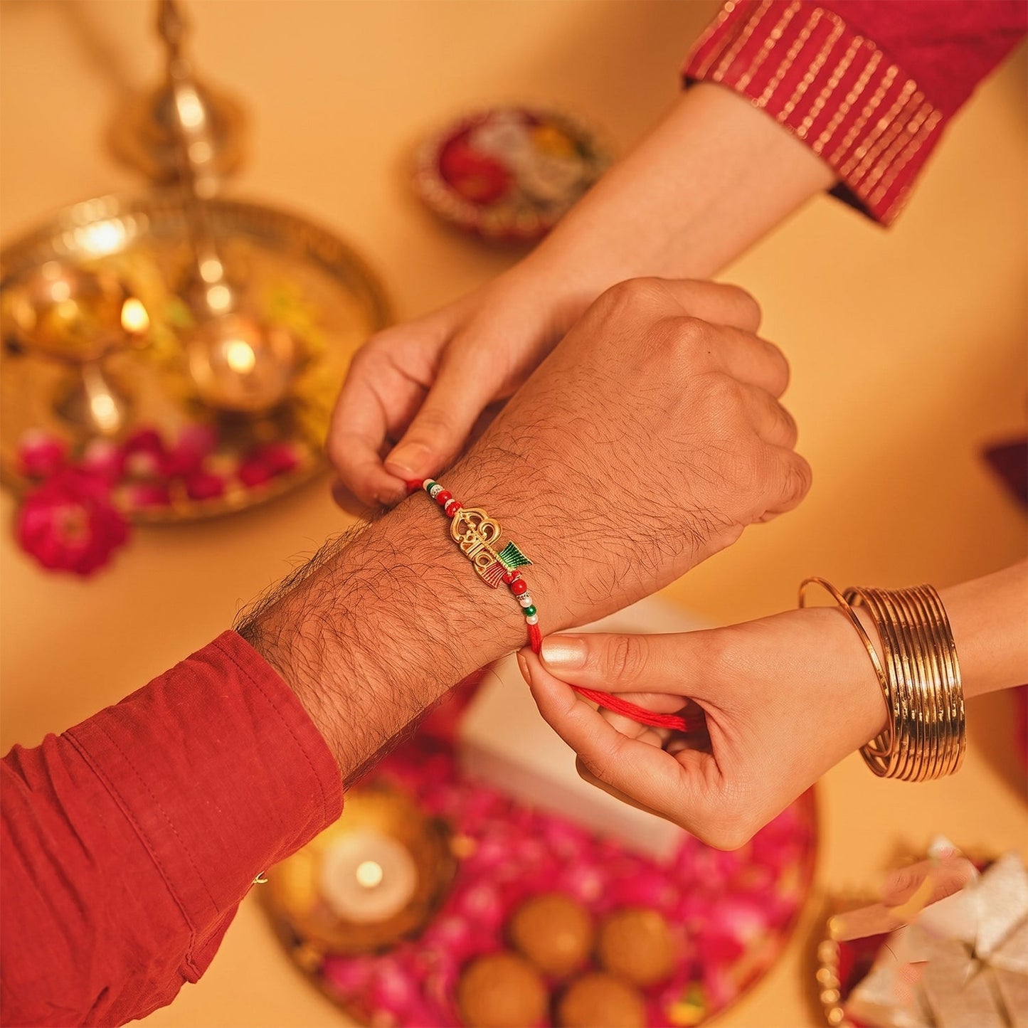 Side view of the traditional Meenakari Rakhi showcasing intricate enamel work and golden finish.