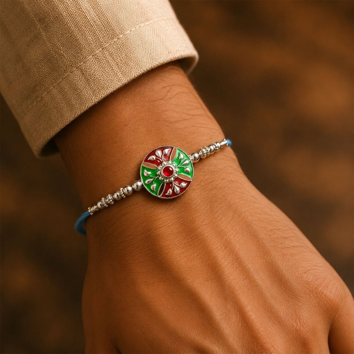 Close-up of meenakari floral design on Rakhi with silver beads