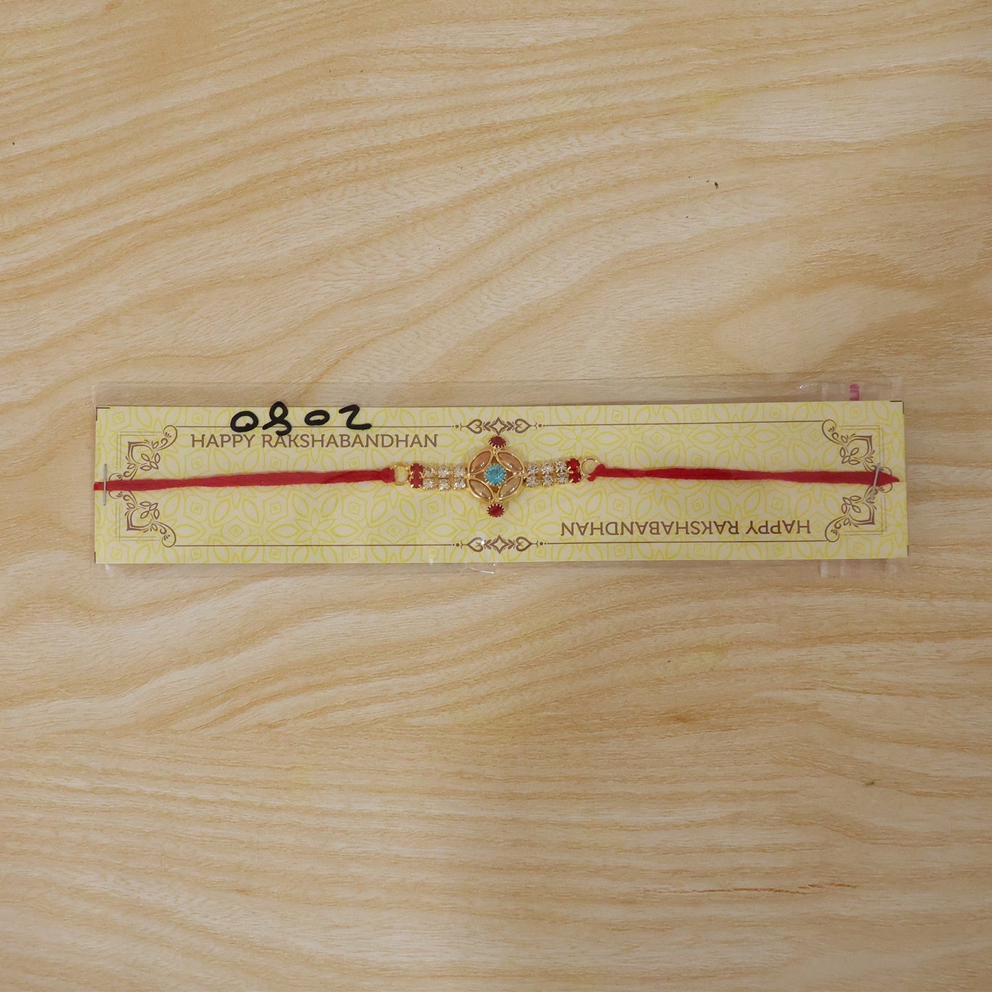 Kundan Rakhi featuring a bright turquoise stone, ready to be tied on a brother's wrist.