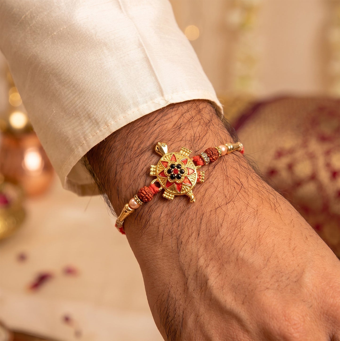 Side view of the designer Golden Tortoise Rakhi showing beaded thread.