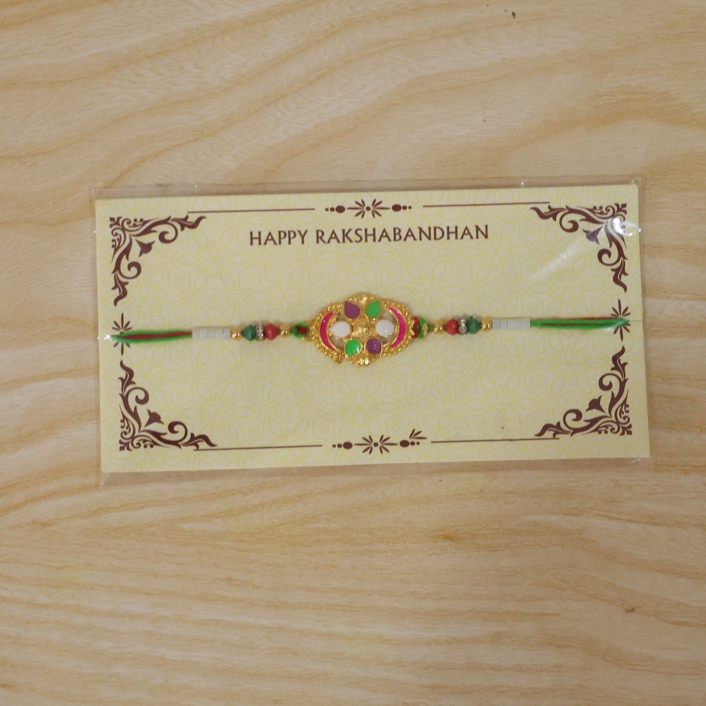 Overhead view highlighting intricate enamel and thread of the Rakhi.