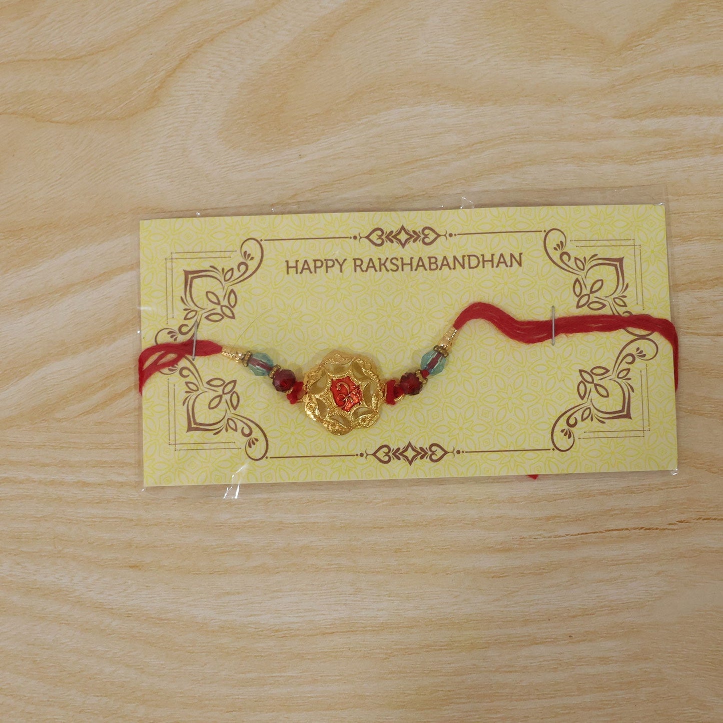 Red stone Rakhi for Brother displayed on a white background, ready for Raksha Bandhan.