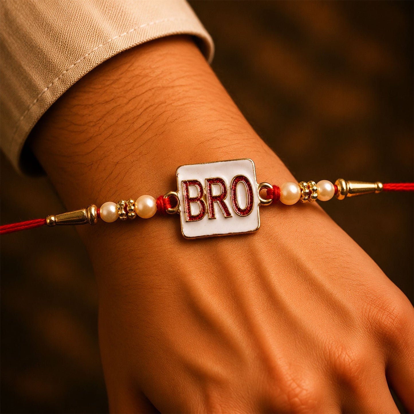 Close-up of the stylish 'BRO' rakhi with pearl details.