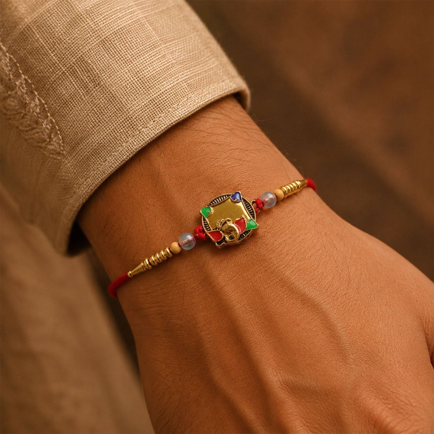 Designer Rakhi featuring golden elephant and vibrant stone work.