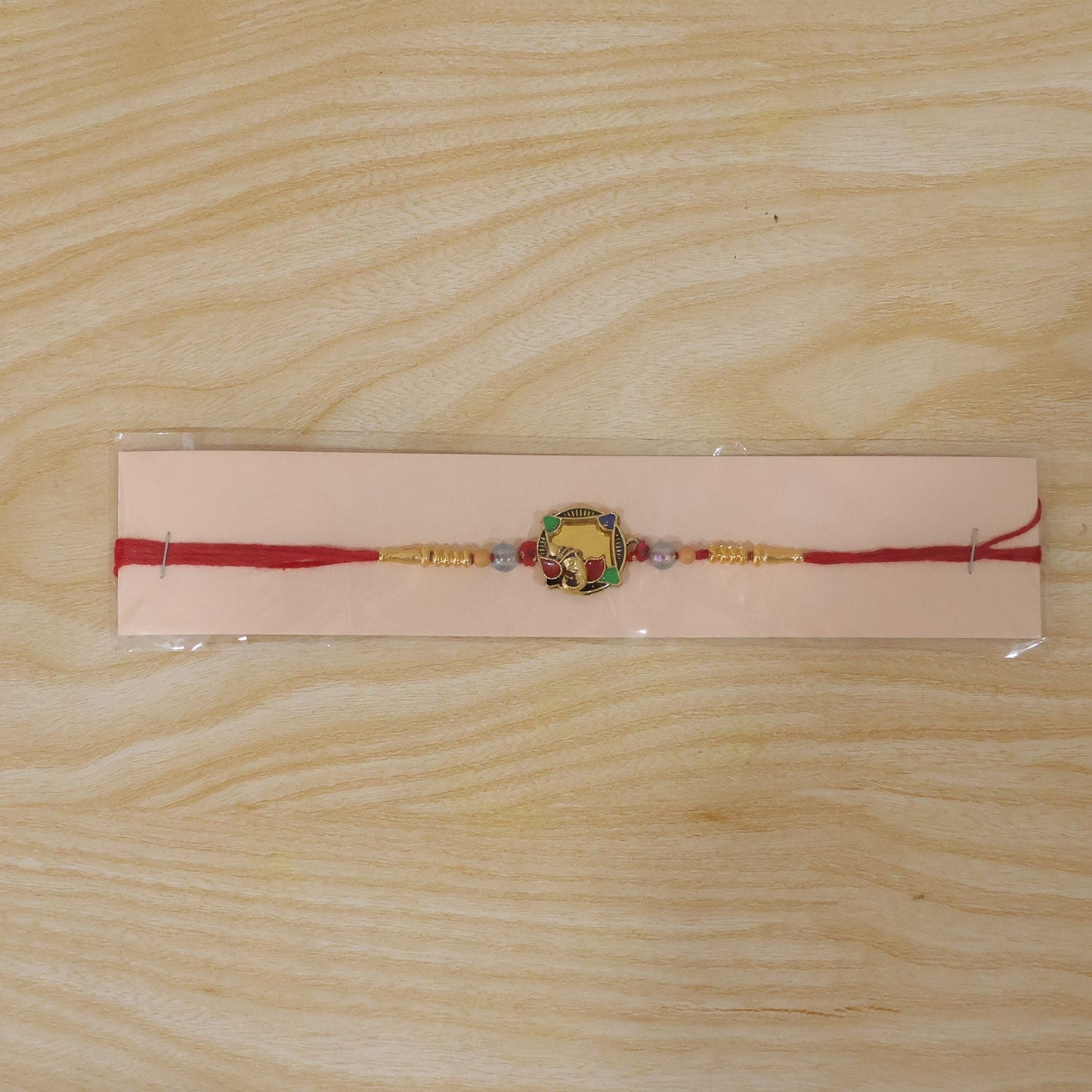 Beautiful golden elephant Rakhi with colourful accents, ideal for festivities.