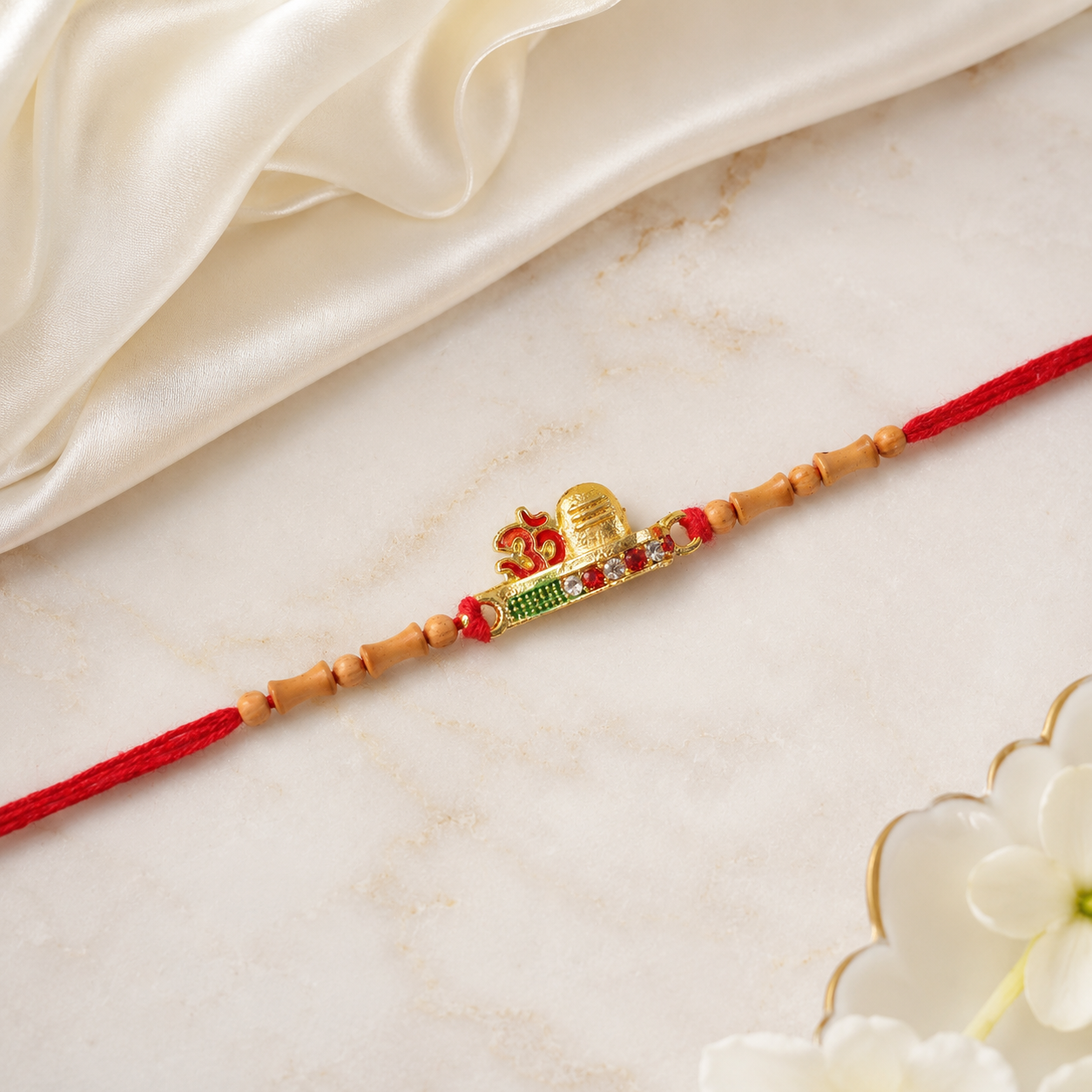 Side view of the golden Om Rakhi, highlighting its vibrant thread and beadwork.