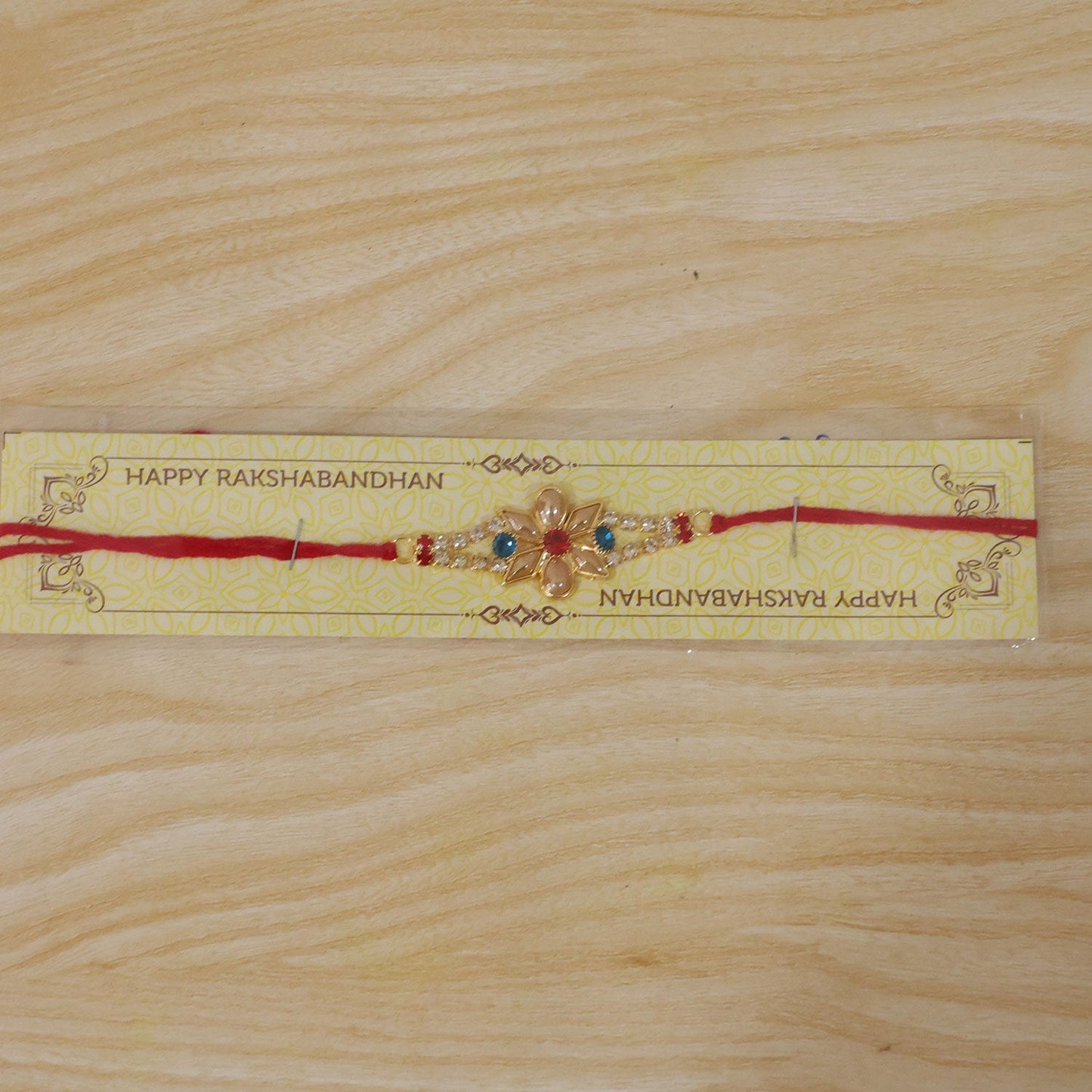 Blue and red stone accented Pearl Flower Rakhi suitable for brothers.