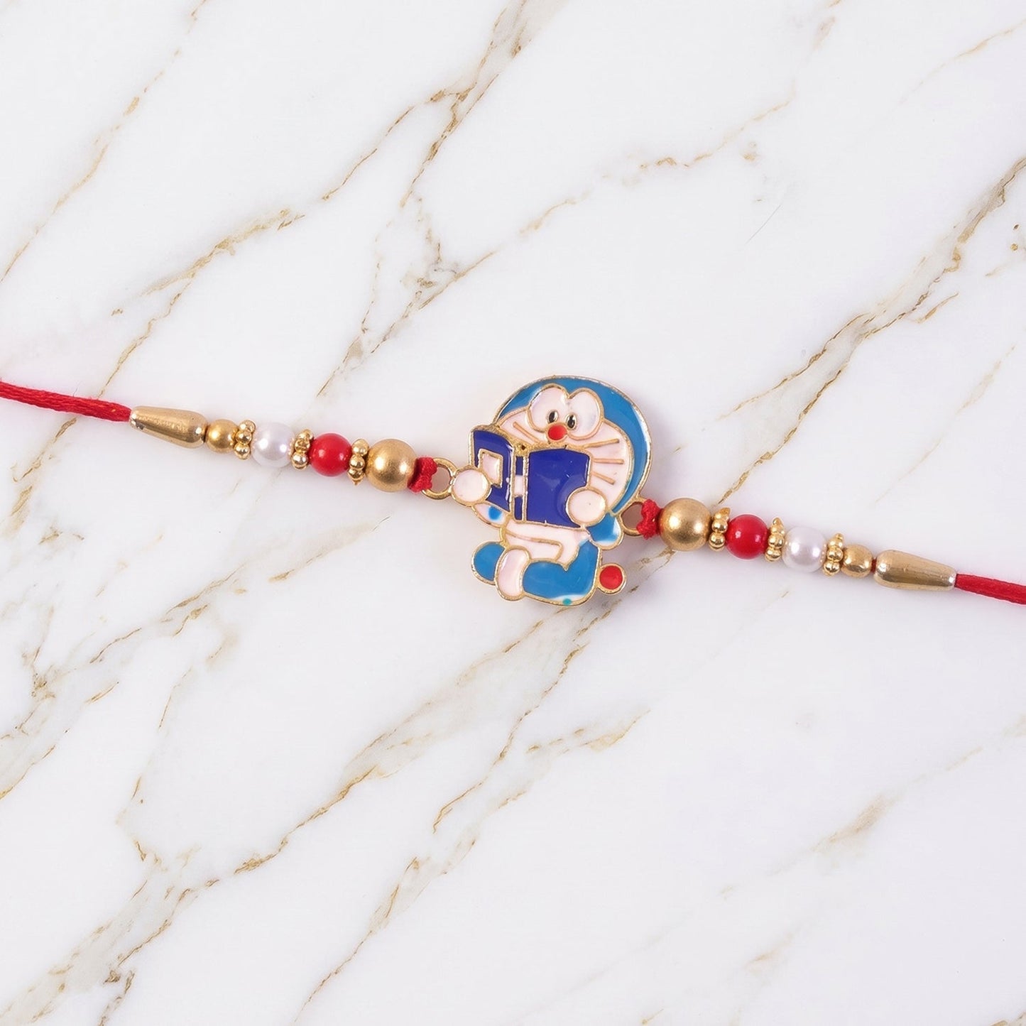Angled view showing intricate beads and thread of the Doraemon rakhi.
