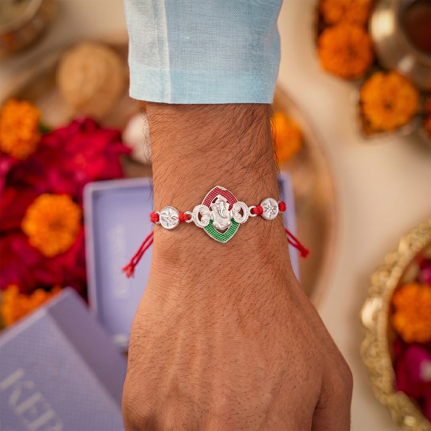 Side view of the Ganesha Meenakari Rakhi highlighting intricate silver and enamel work.