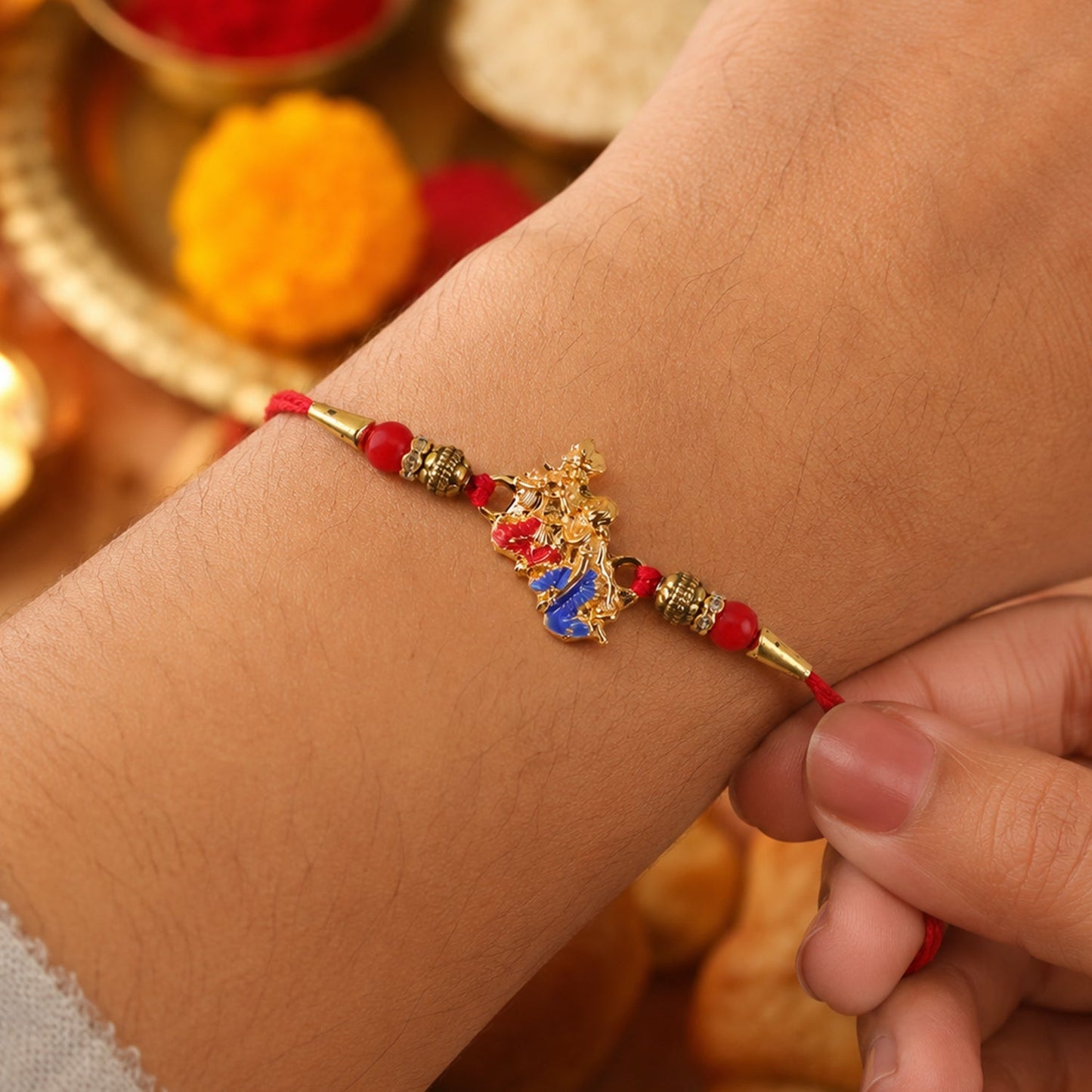 Traditional Golden Peacock Rakhi adorned with vibrant blue enamel and red beads