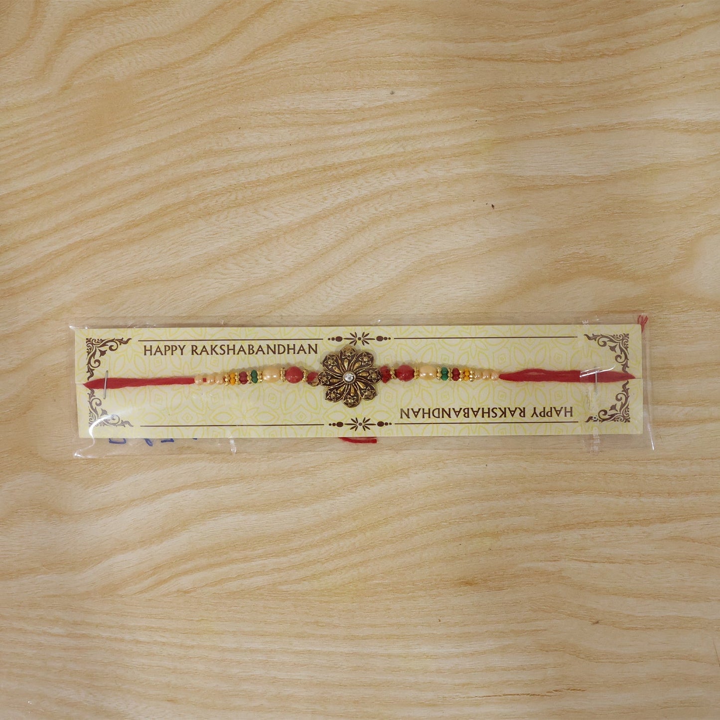 Antique floral rakhi worn on wrist demonstrating size and fit