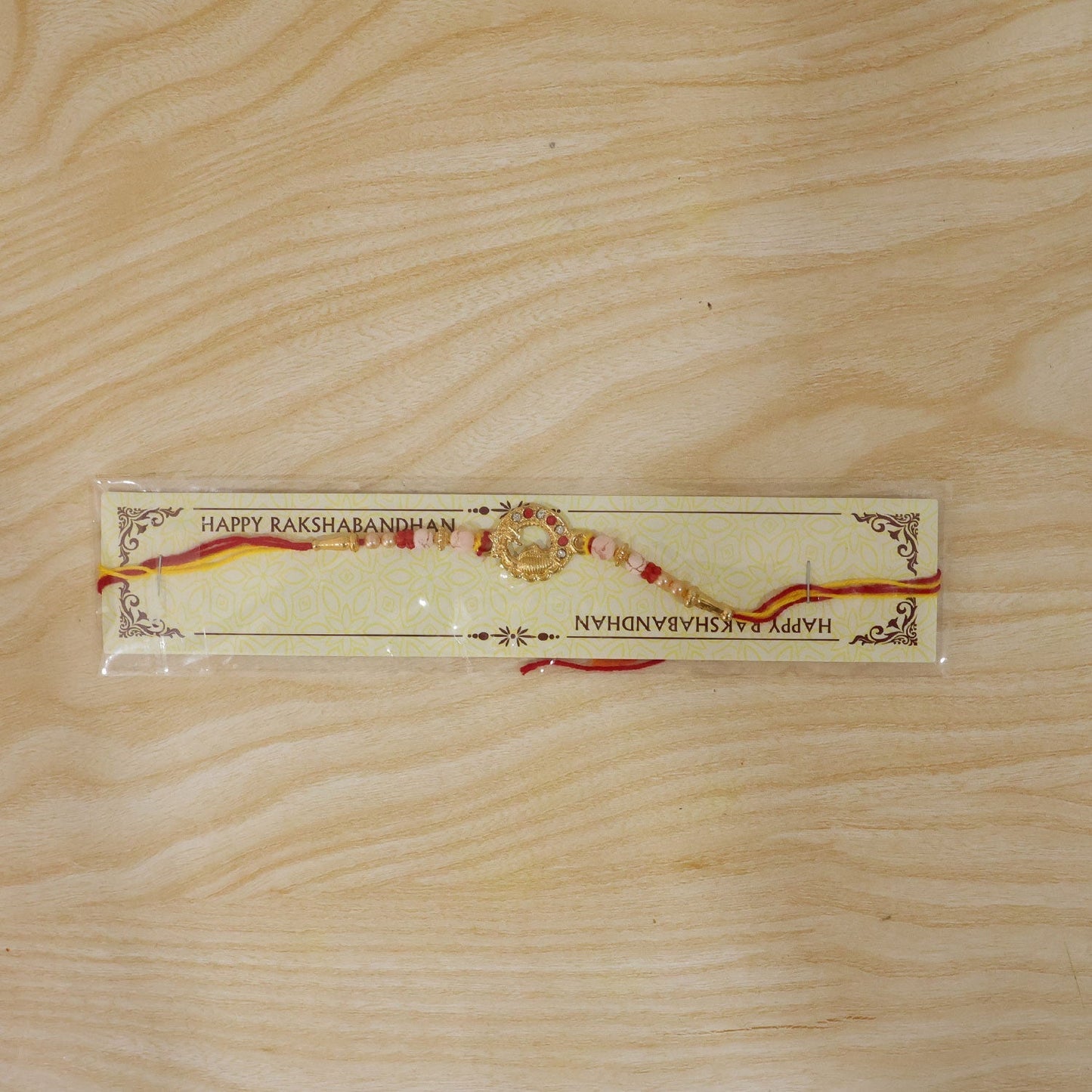 Golden peacock rakhi with comfortable red thread.