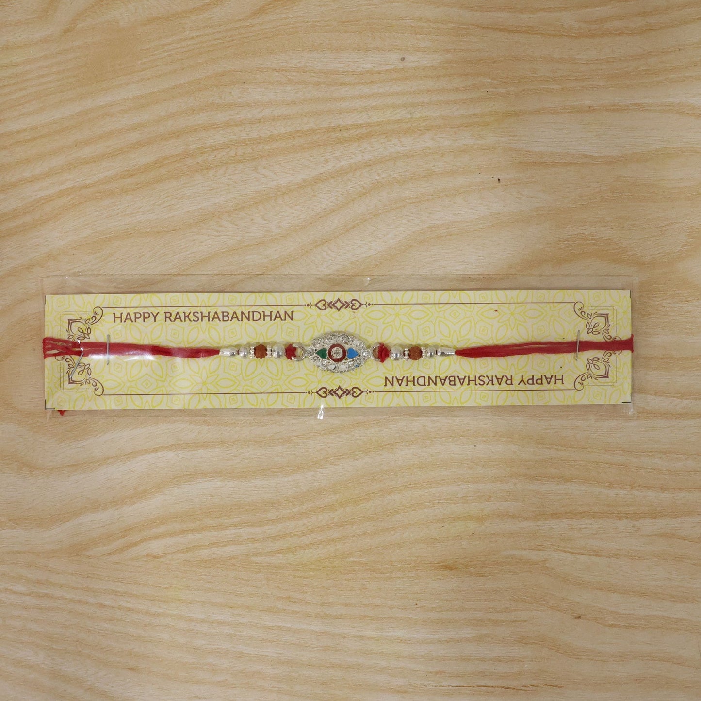 Silver stone designer Rakhi tied around cushion