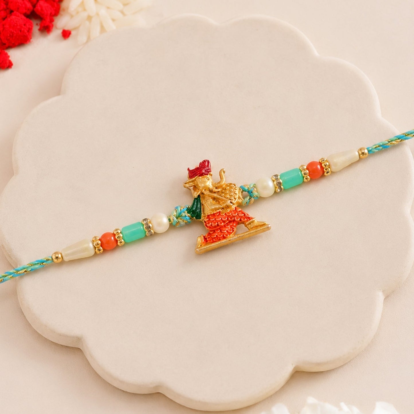 Side view of Ganesh Charm Rakhi showing thread and bead accents