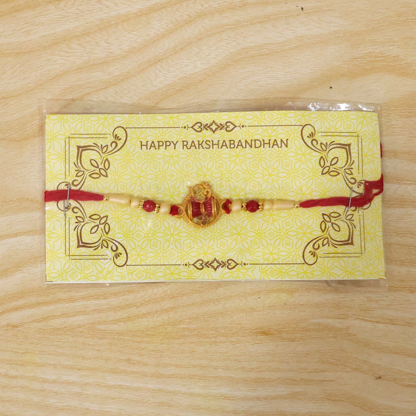Back view of Om Damaru Charm Red Thread Rakhi with beads.