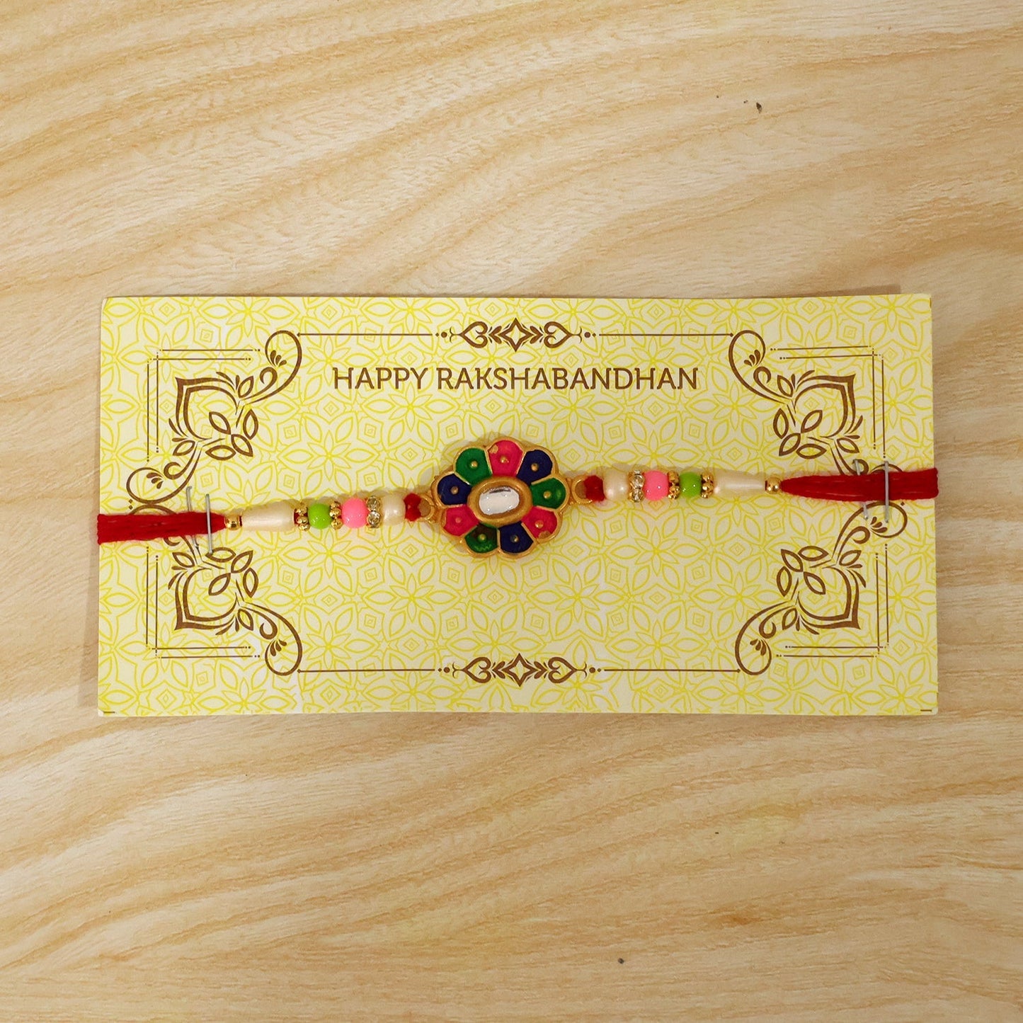 Elegant rakhi with pearls and floral centerpiece