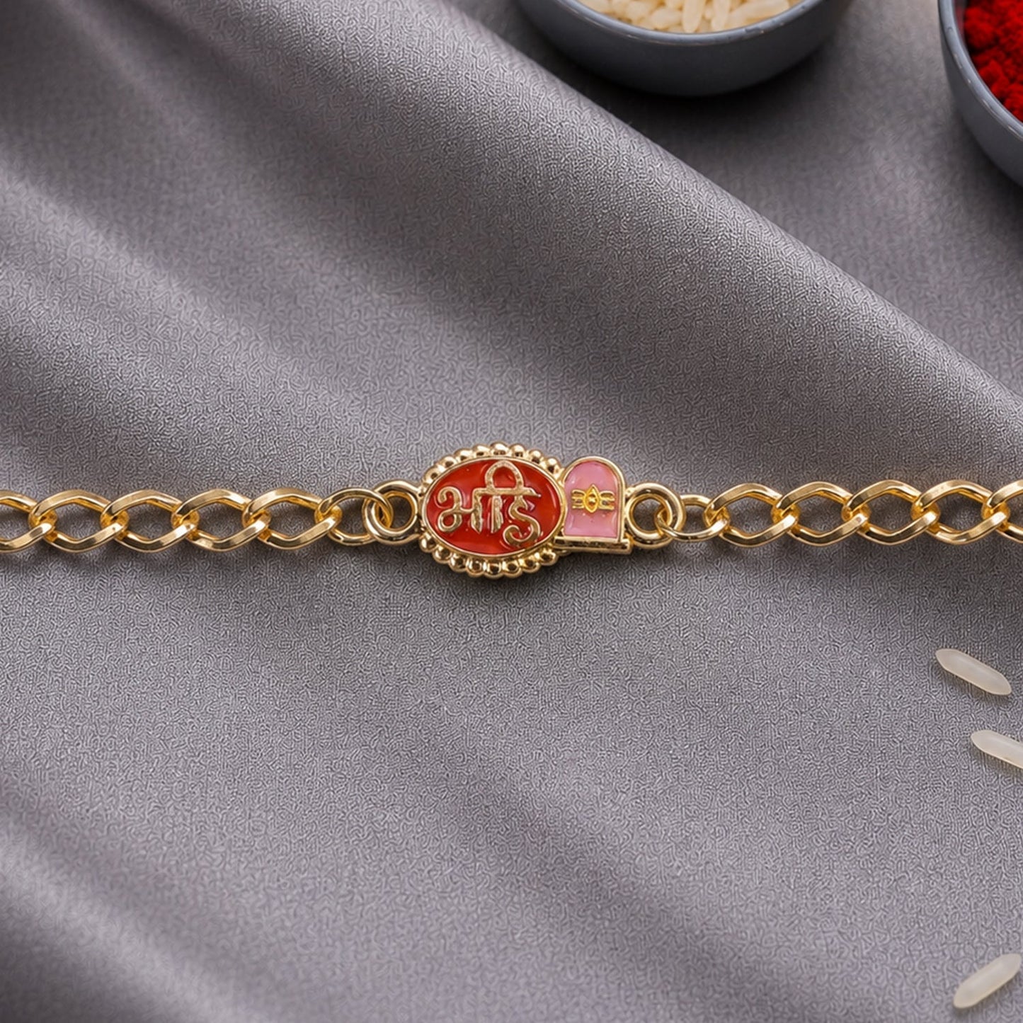 Side view of red enamel Bhai Rakhi bracelet with gold tone finish