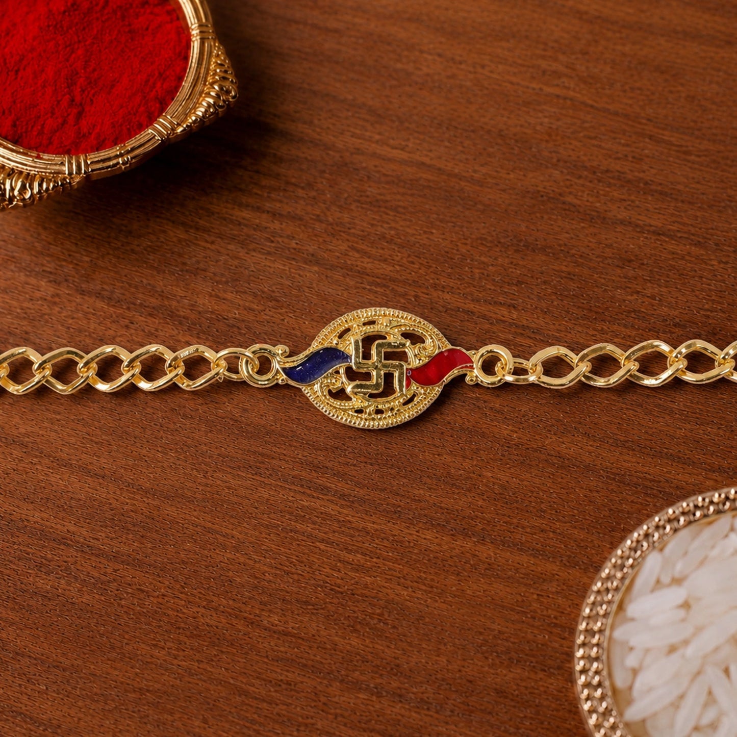 Close-up of Swastik enamel gold-tone rakhi centerpiece