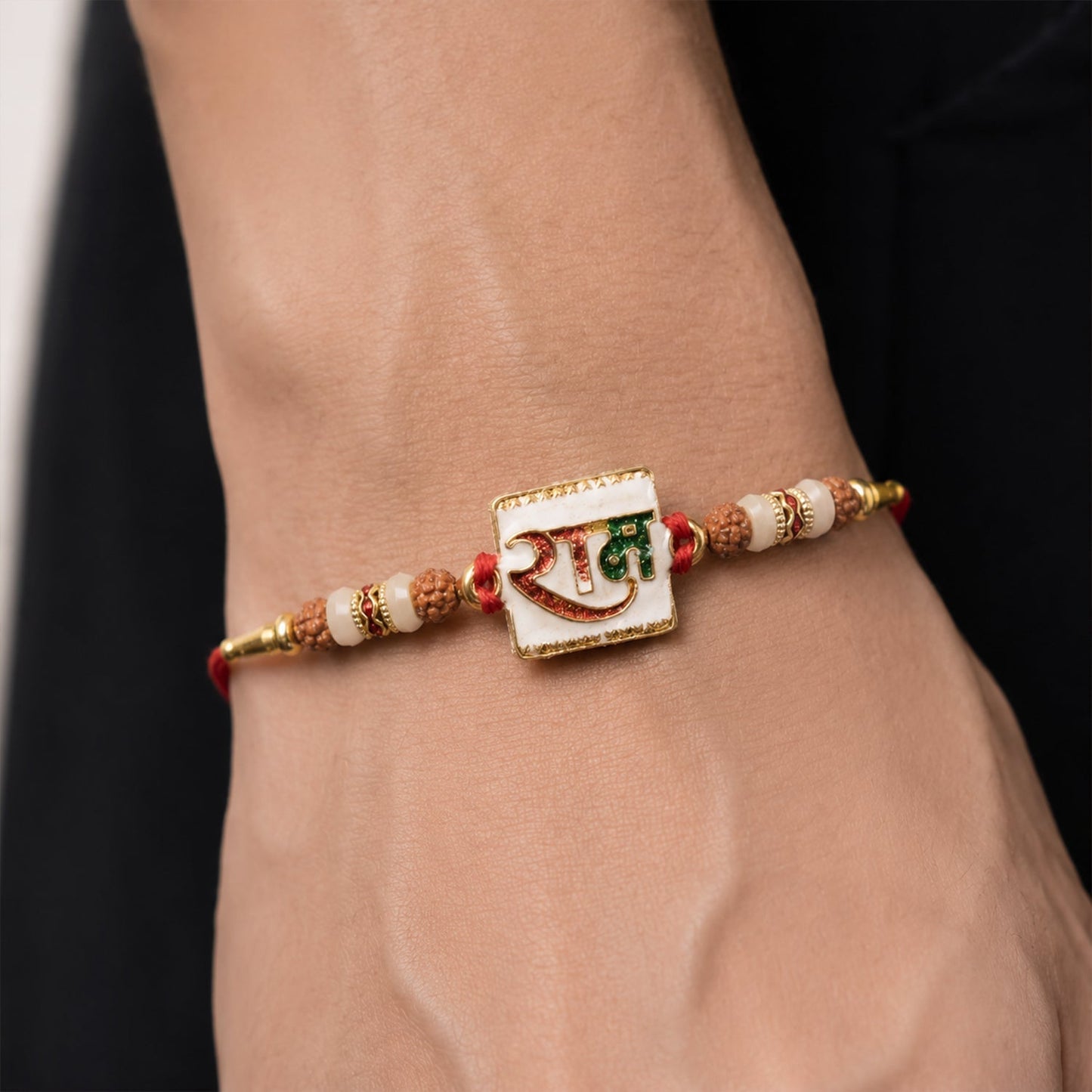 Side view of Ram Text White Enamel Gold Tone Rakhi showing craftsmanship