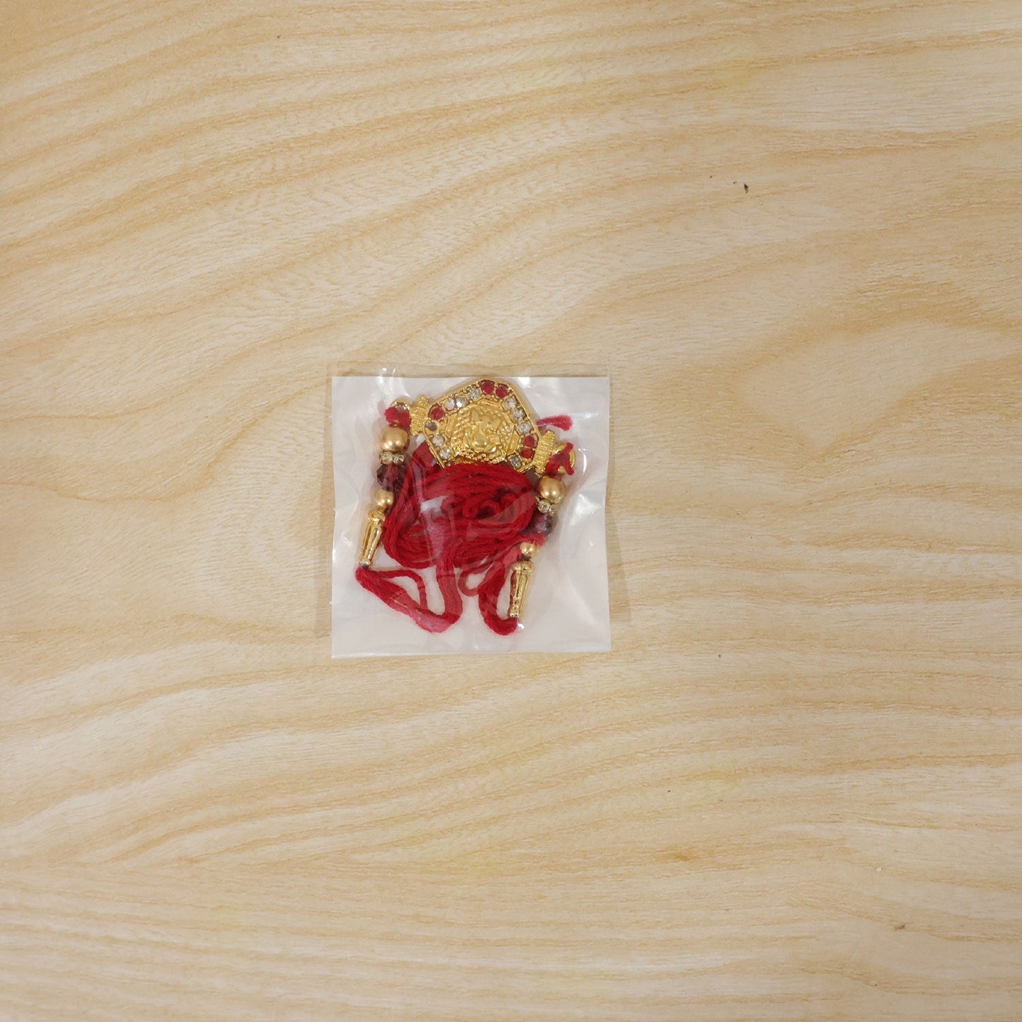 Decorative Lord Ganesha Rakhi with vibrant red and gold, Raksha Bandhan gift